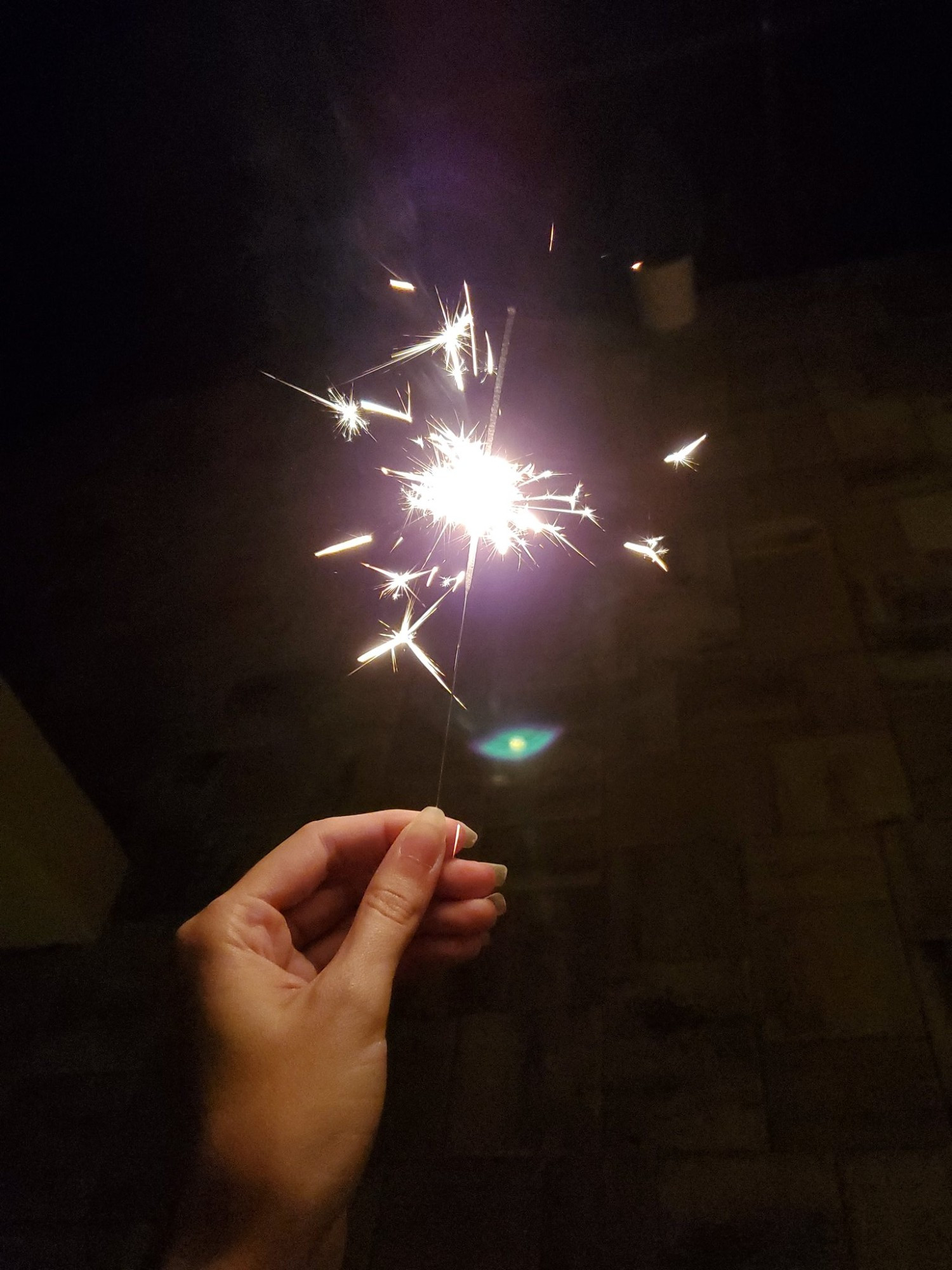 A stock photo of a hand holding a sparkler.