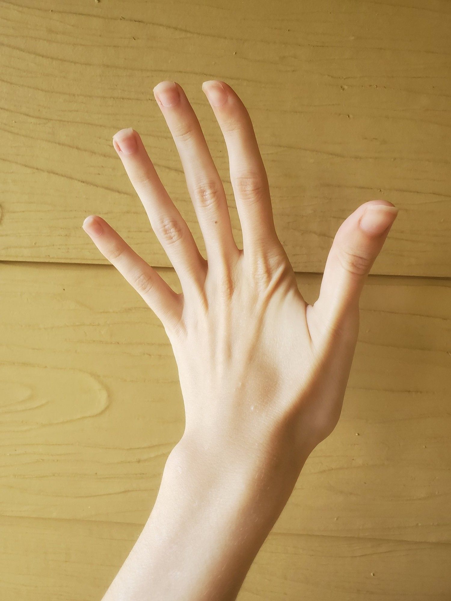 A stock photo reference of a hand, palm facing away, fingers strained backwards.