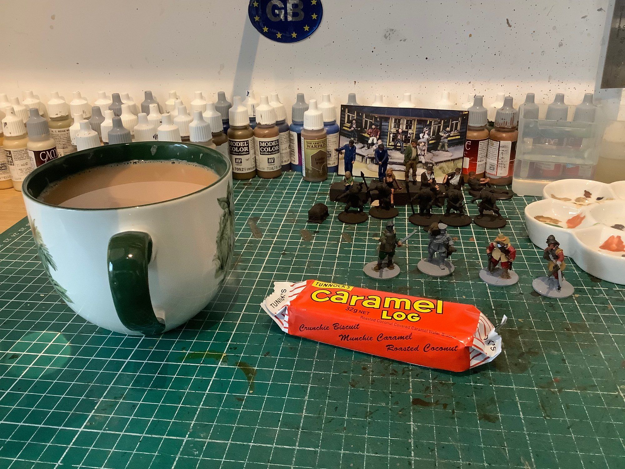 An afternoon break. 

Photo of a mug of tea, with an Tunnock’s “Caramel Log” in orangey red wrapper, on a work bench. Various part painted miniatures and bottles of paint form the back drop. 

Taking it easy whilst the storm rages overhead ⚡️🌨️⚡️