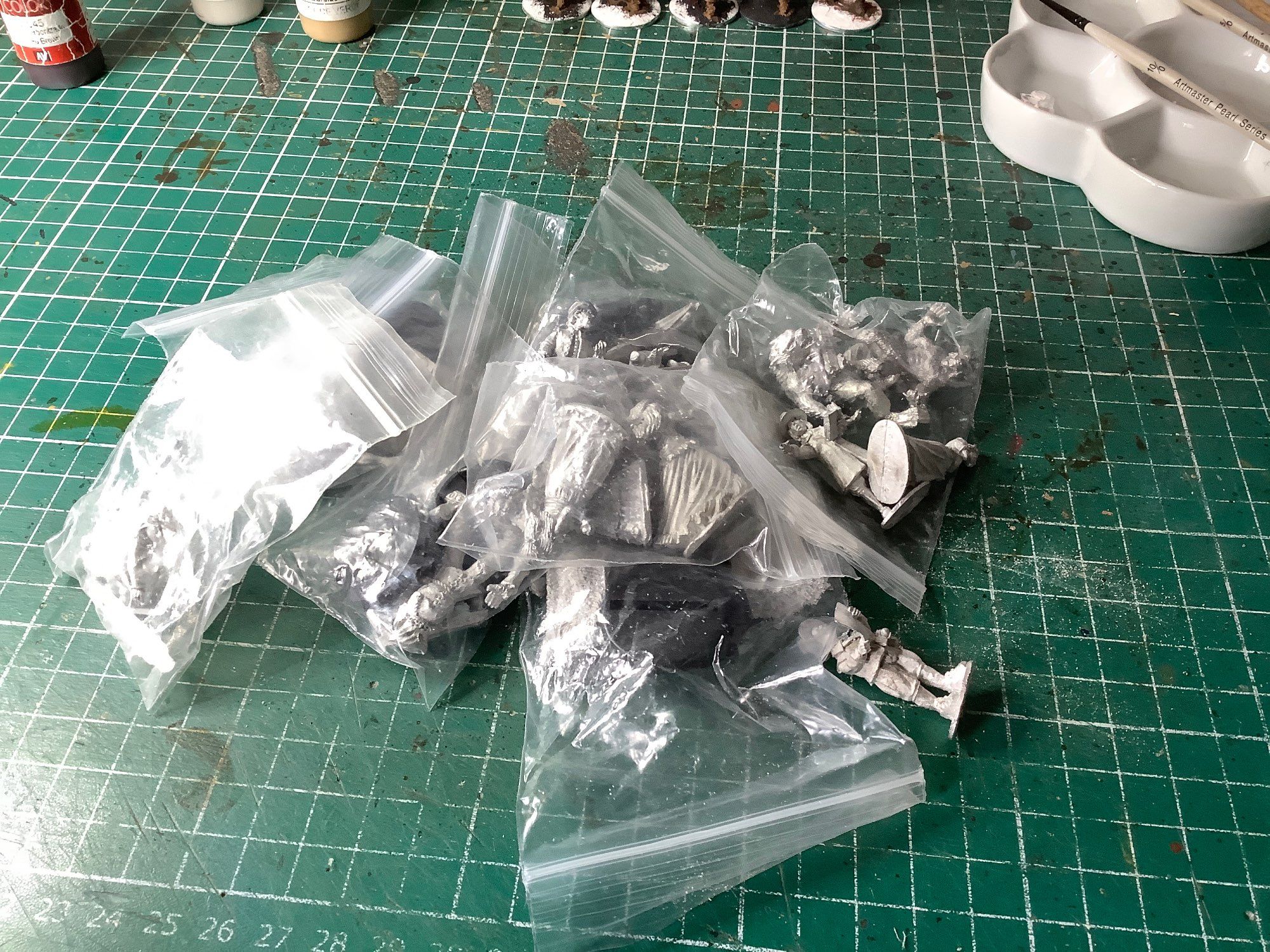 Phot of a pile of 28mm metal miniatures in plastic bags waiting to be based and painted.