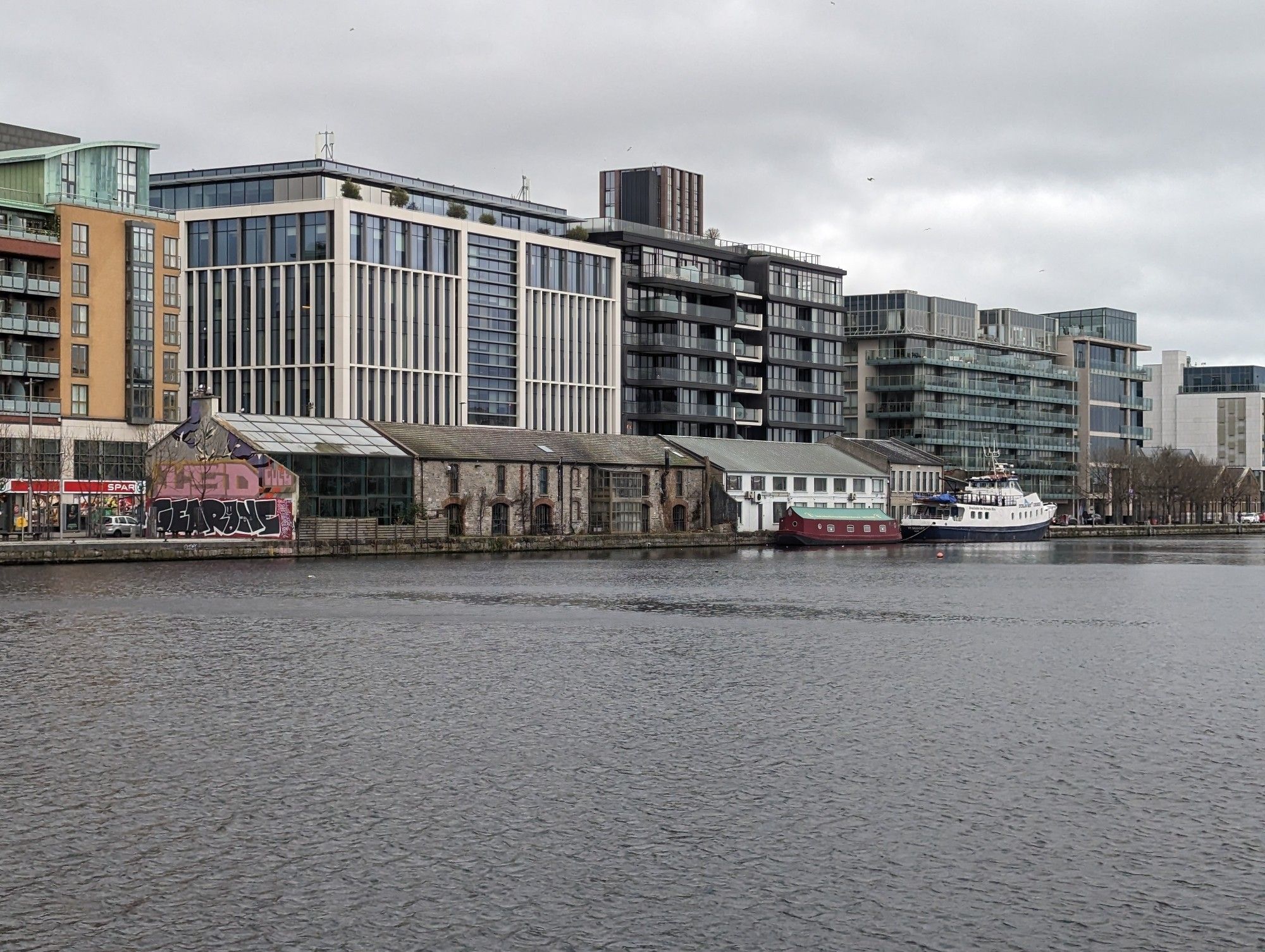 Grey, ugly city scape by the waterfront. Steel and glass five-over-ones. A small row of old varyingly renovated warehouses. Nothing green.