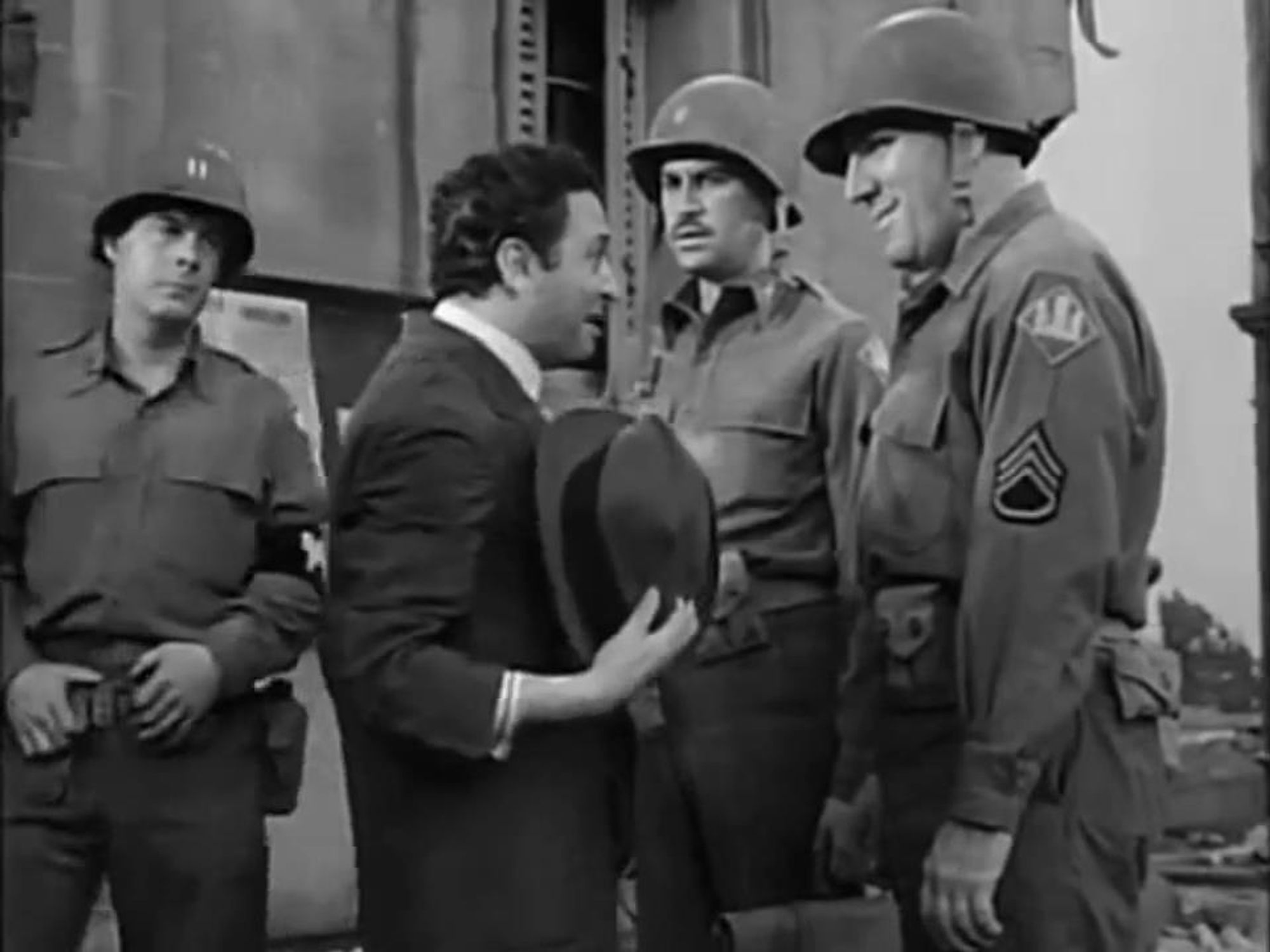 Harry Morgan, John Hodiak and William Bendix in uniform meet Marcel Dalio, a resident of Adano.