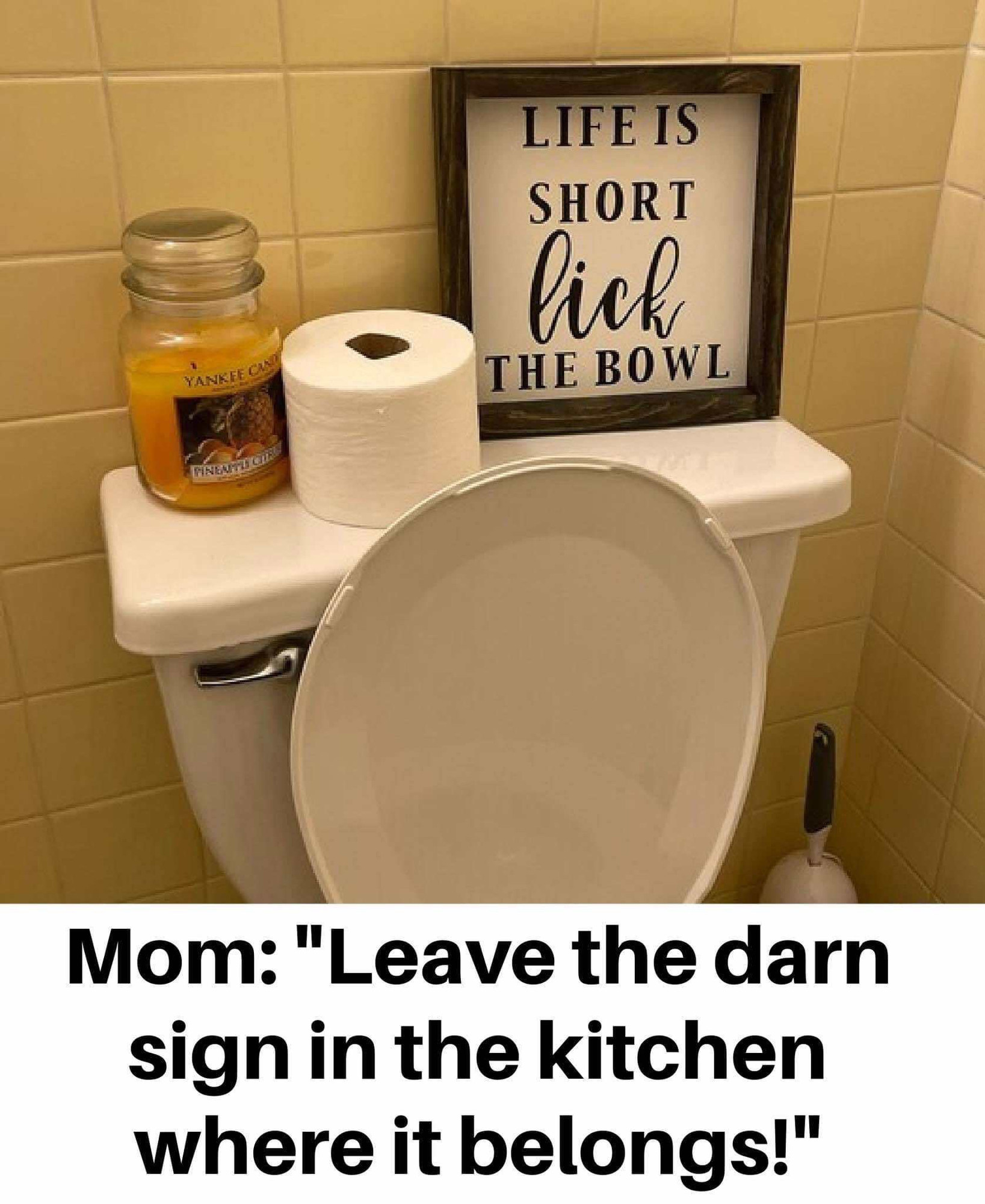 Photo of a bathroom with a sign “Life is short, lick the bowl” and the caption “Mom: Leave the darn sign in the kitchen where it belongs”