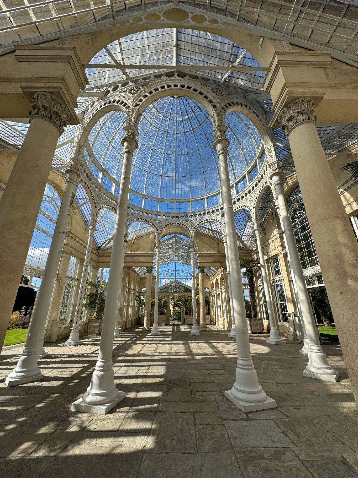 A view inside a large glass dome supported by ornate ironwork.