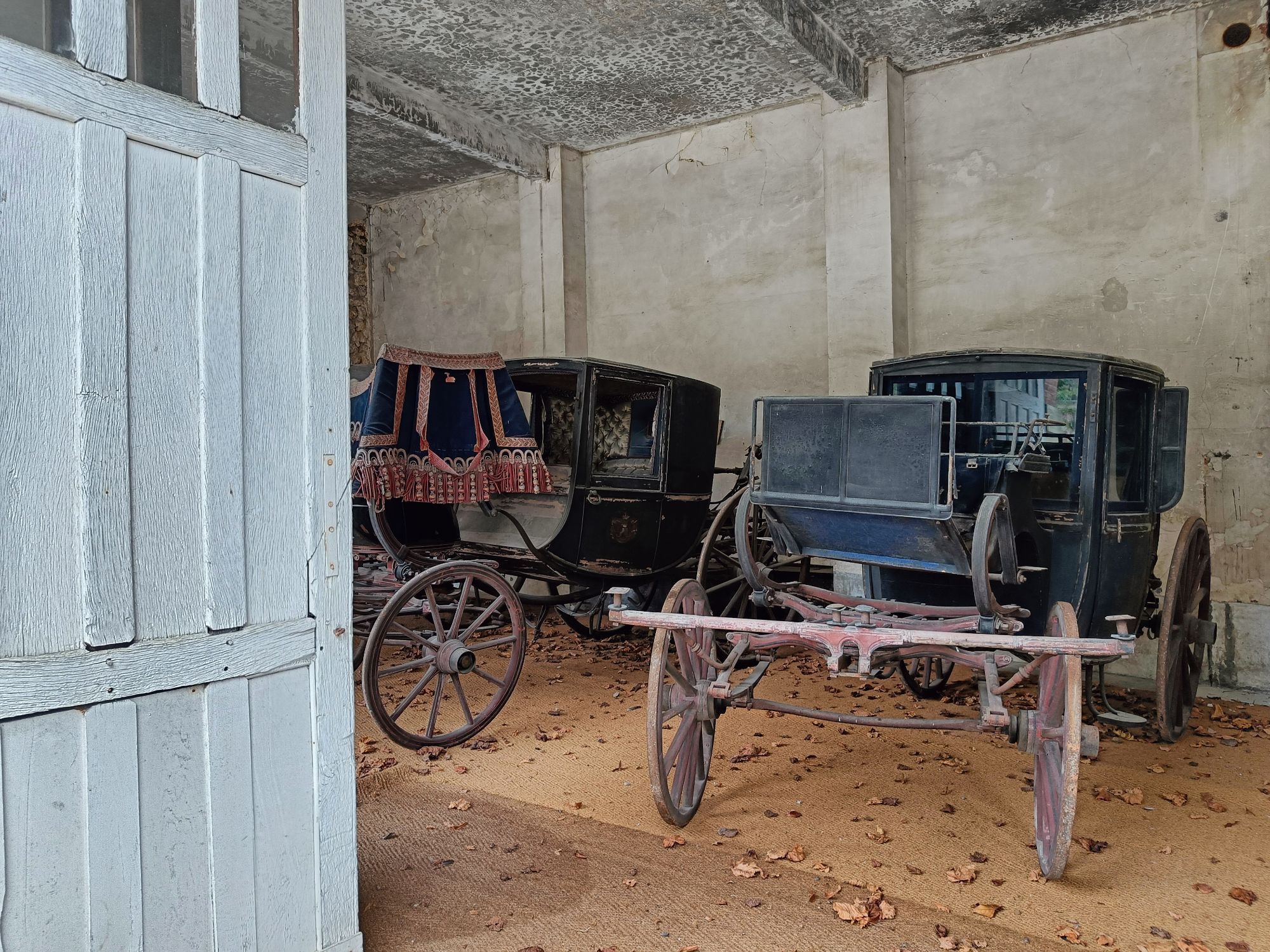 Old carriages on display in an outbuilding