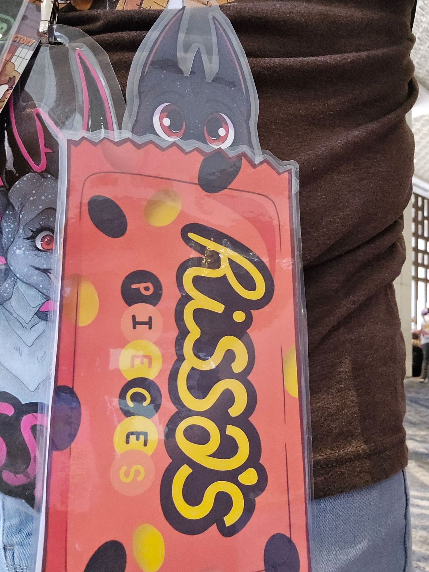 Rissa's new badge! "Rissa's Pieces"; Rissa is poking her head out of a bag of candy