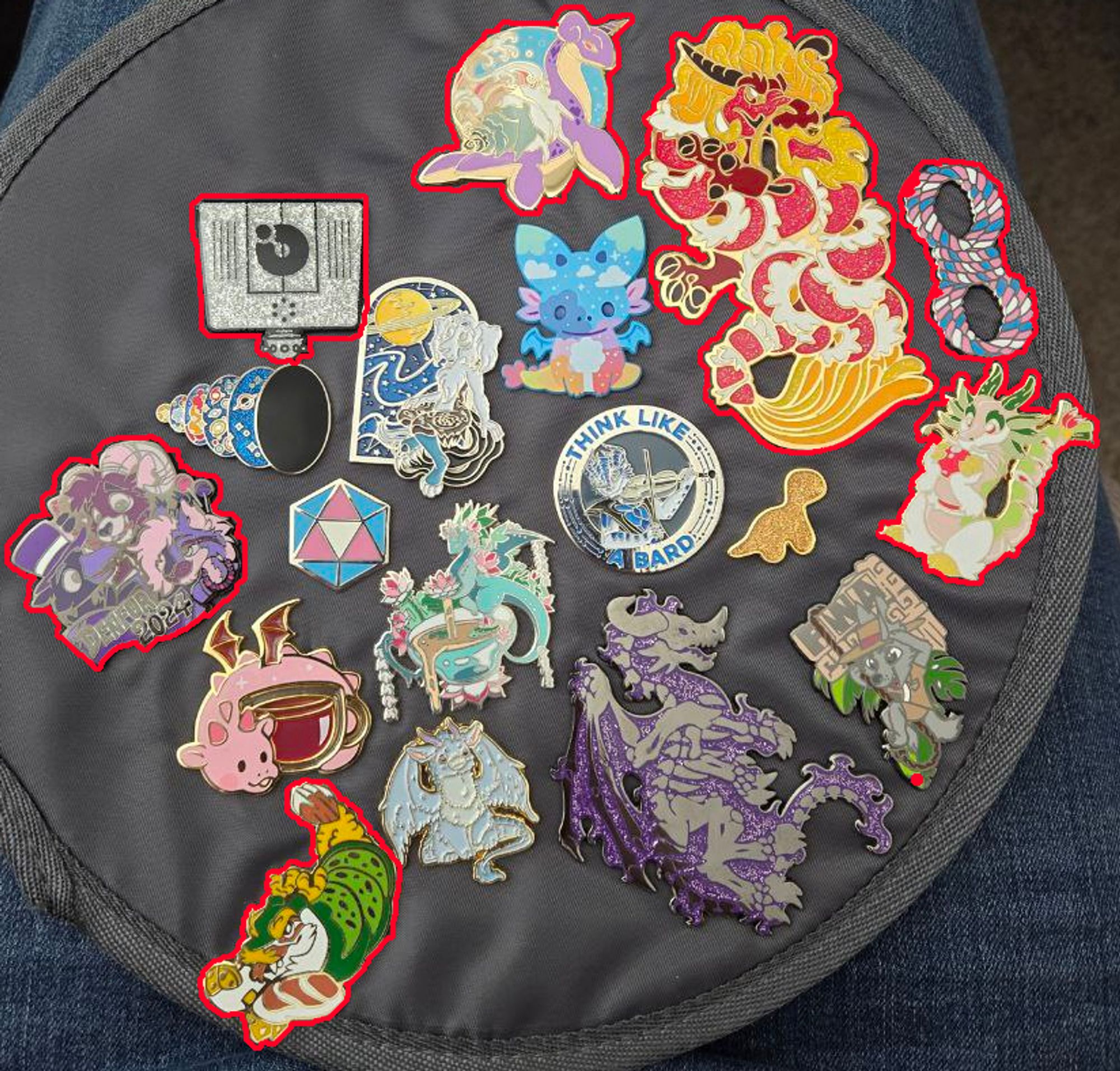 A collection of enamel pins, seven of which have been highlighted as new additions. QDot, Denfur 2024, White Dragon Roll, Dragon Roll, Red Dragon Roll, Lapras, and a coil of rope in trans colors.