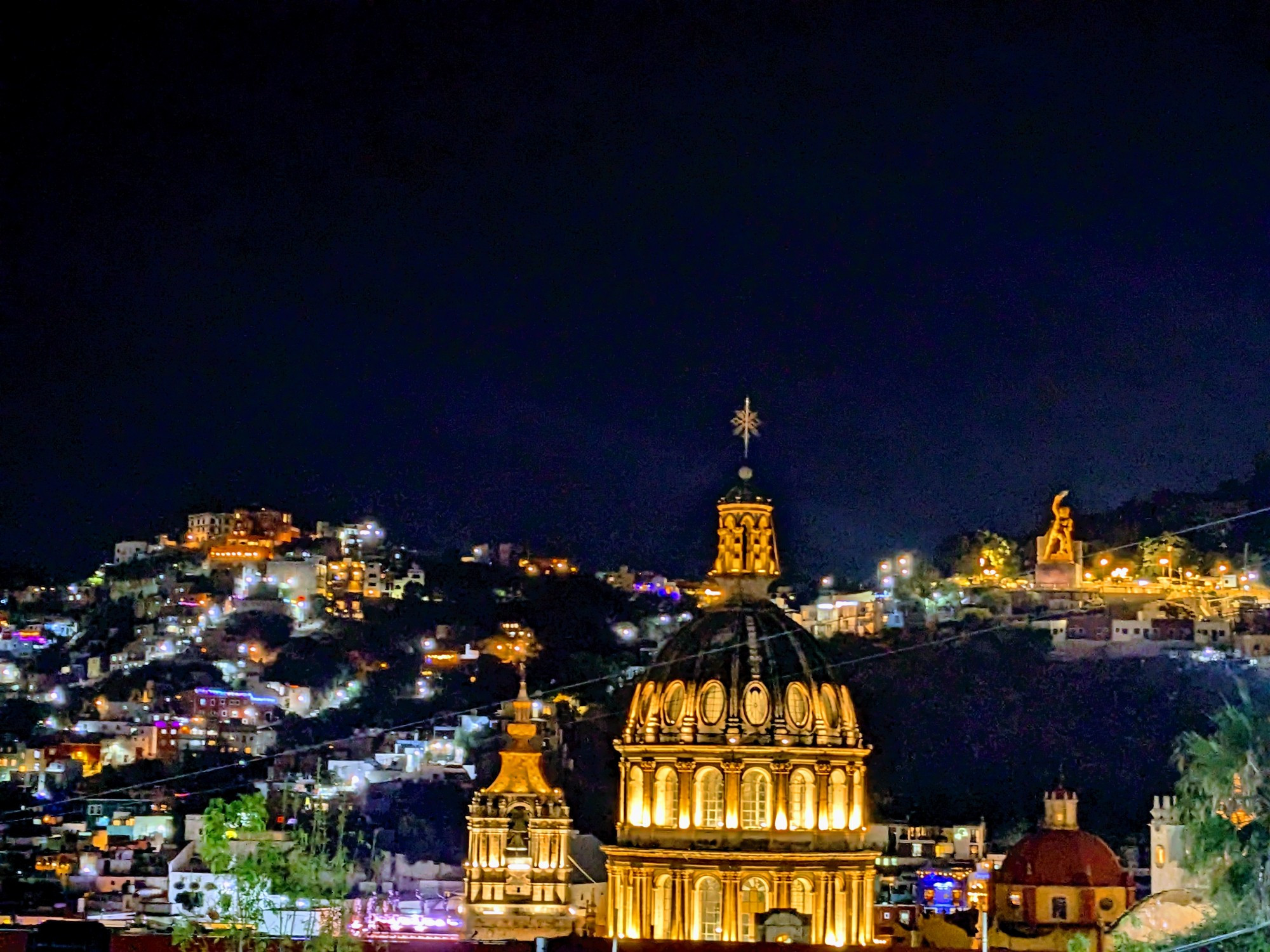 An inky black sky above the warm lights of an old city cascading across the hillsides 