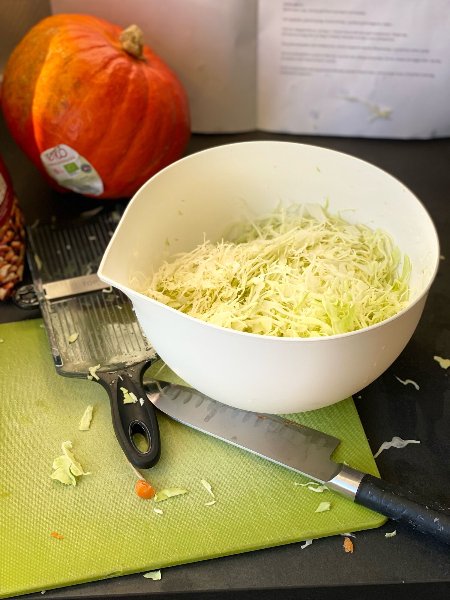 Shredded cabbage with various kitchen implements around it