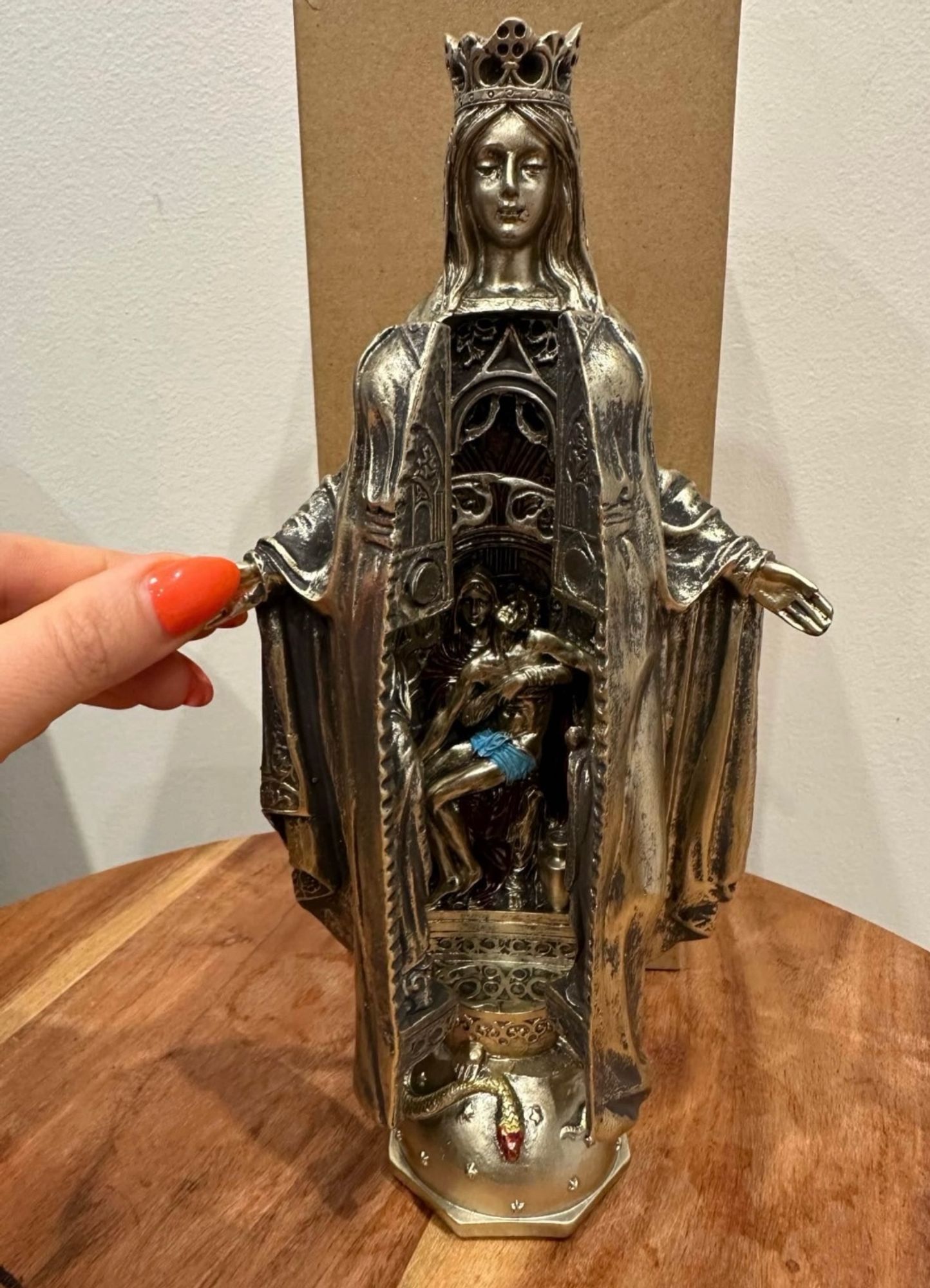 A statue of the Virgin Mary half-open revealing a crucified Jesus inside her