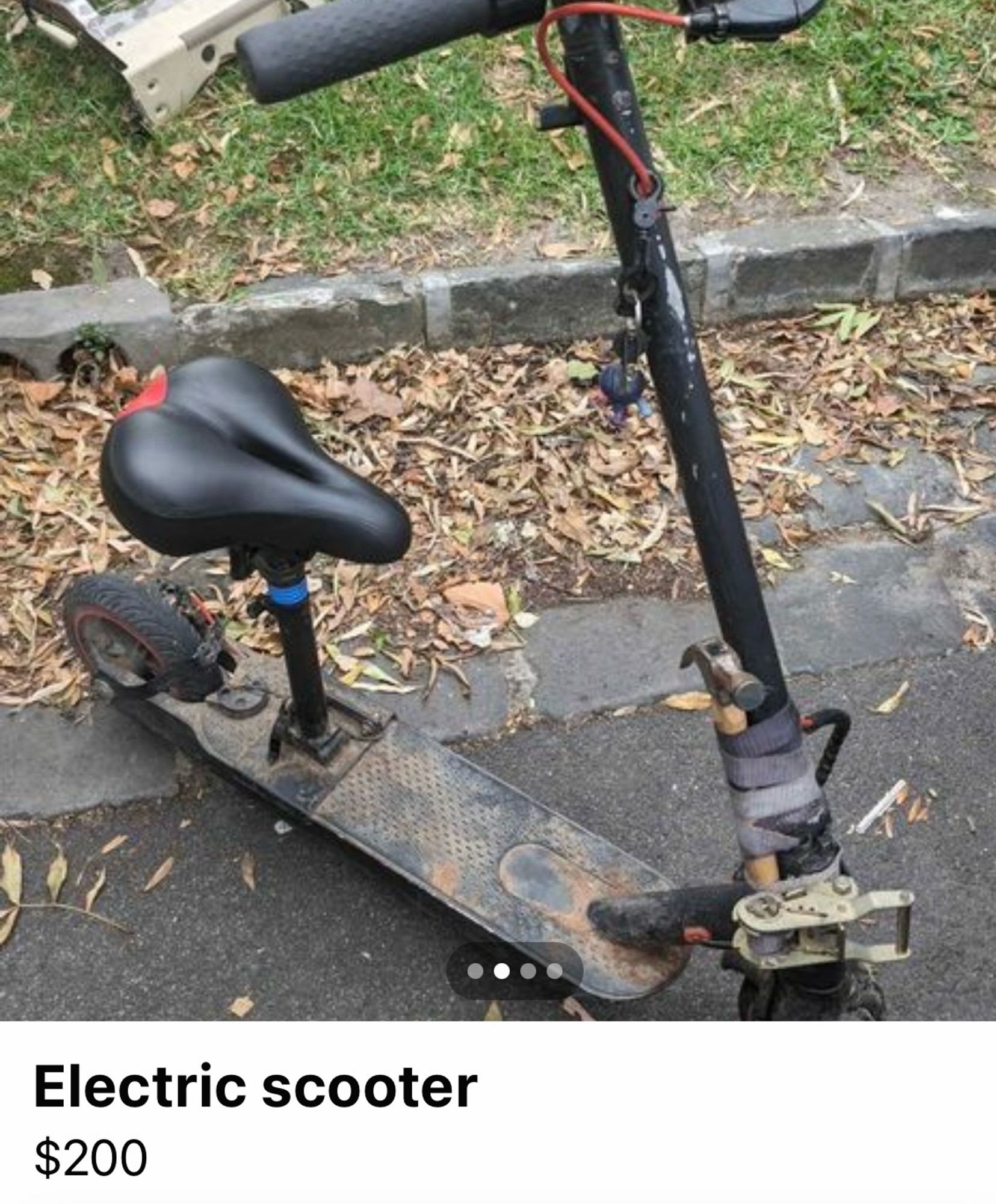 An electric scooter which has been repaired by strapping a claw hammer to the front shaft with a bit of cloth tape