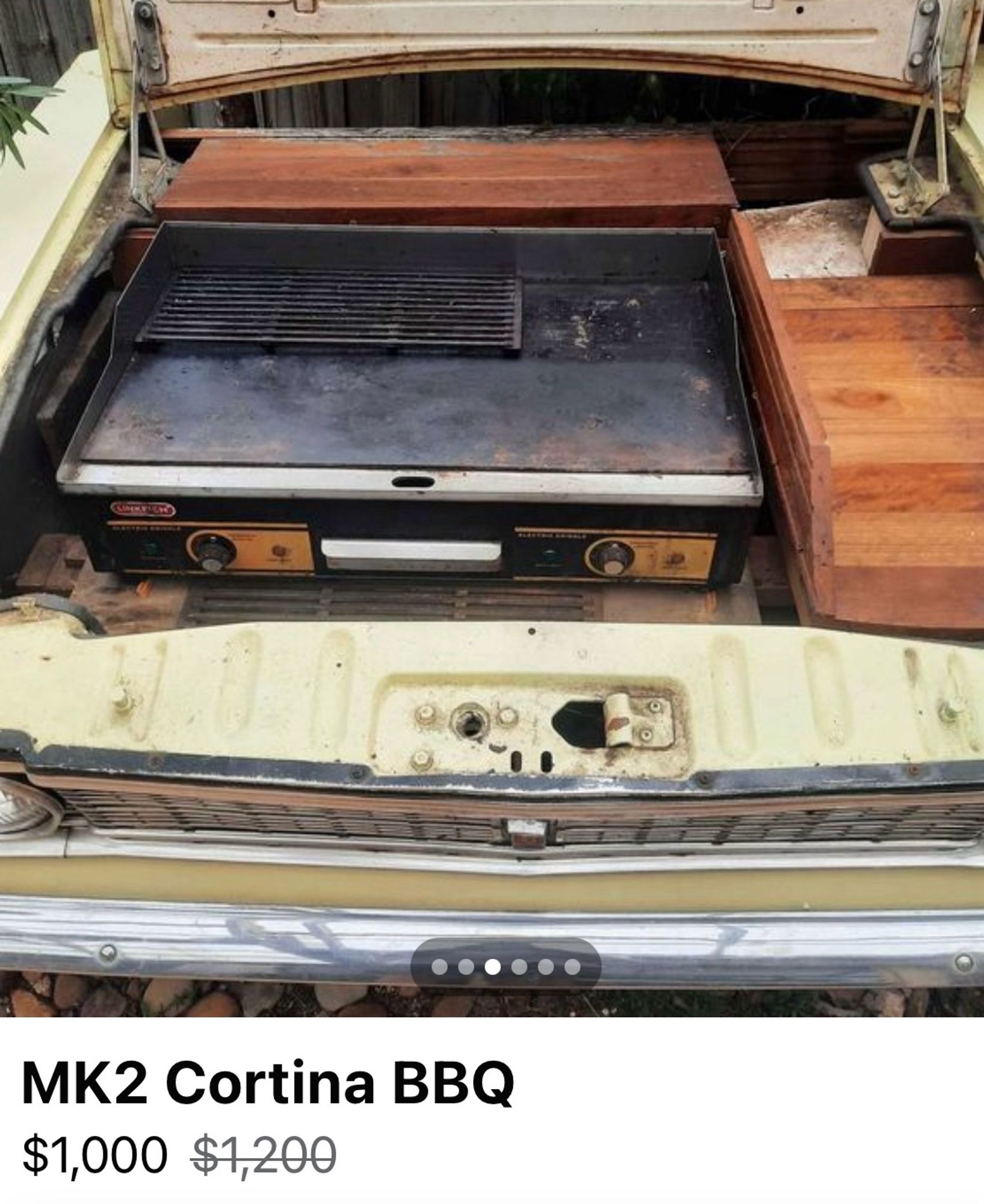 The front end of an old Ford Cortina that has been neatly sawn off the body of the car – lifting the bonnet reveals a BBQ where the motor should be