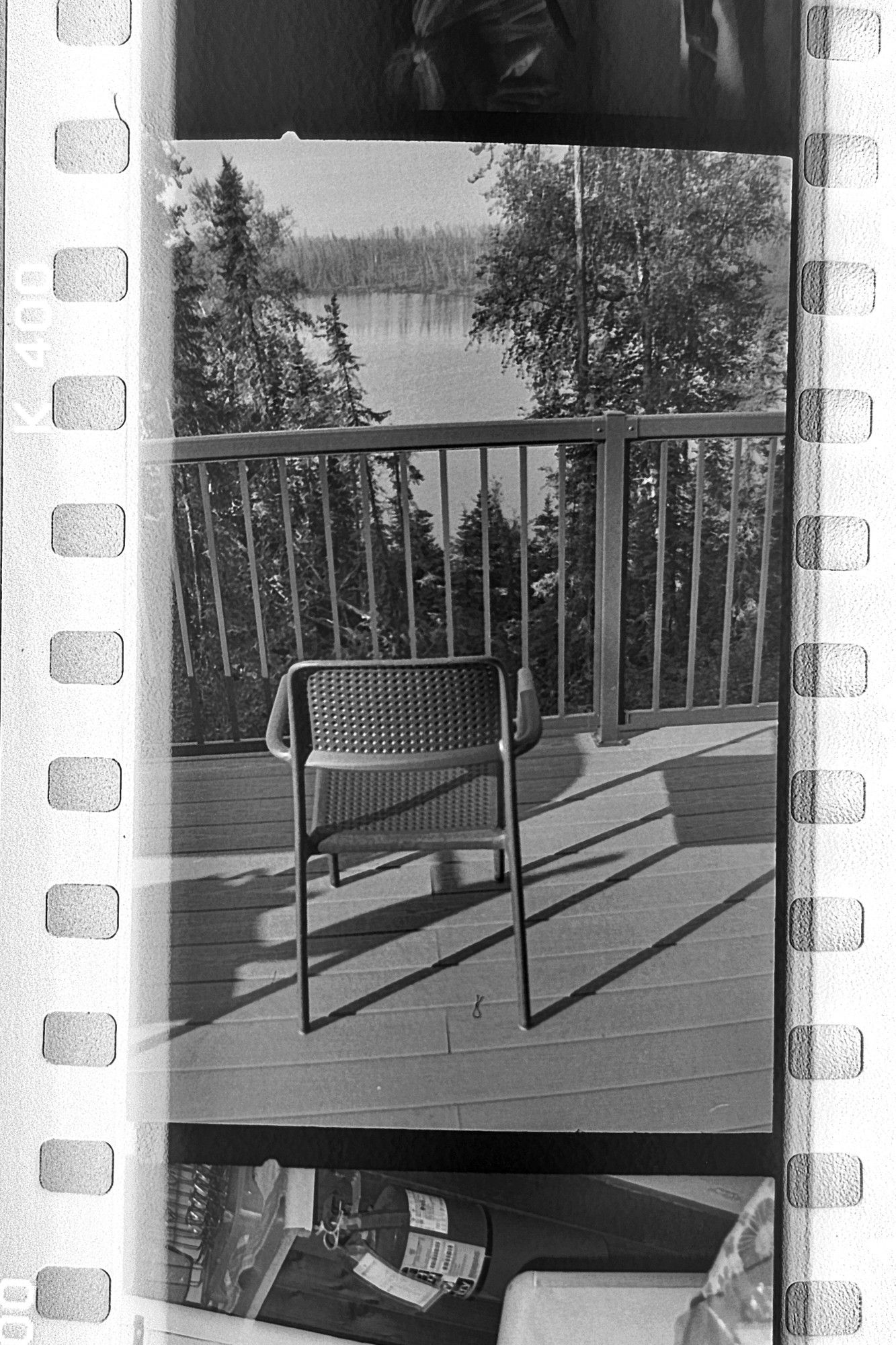 A chair looks out at a lake.