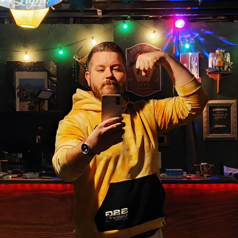 Me in a yellow hoodie flexing selfie with disco lights in the background.