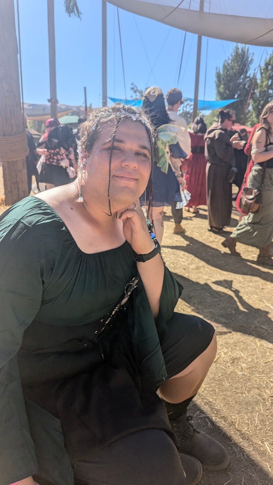 Picture of me sitting down in my Renaissance dress smiling.