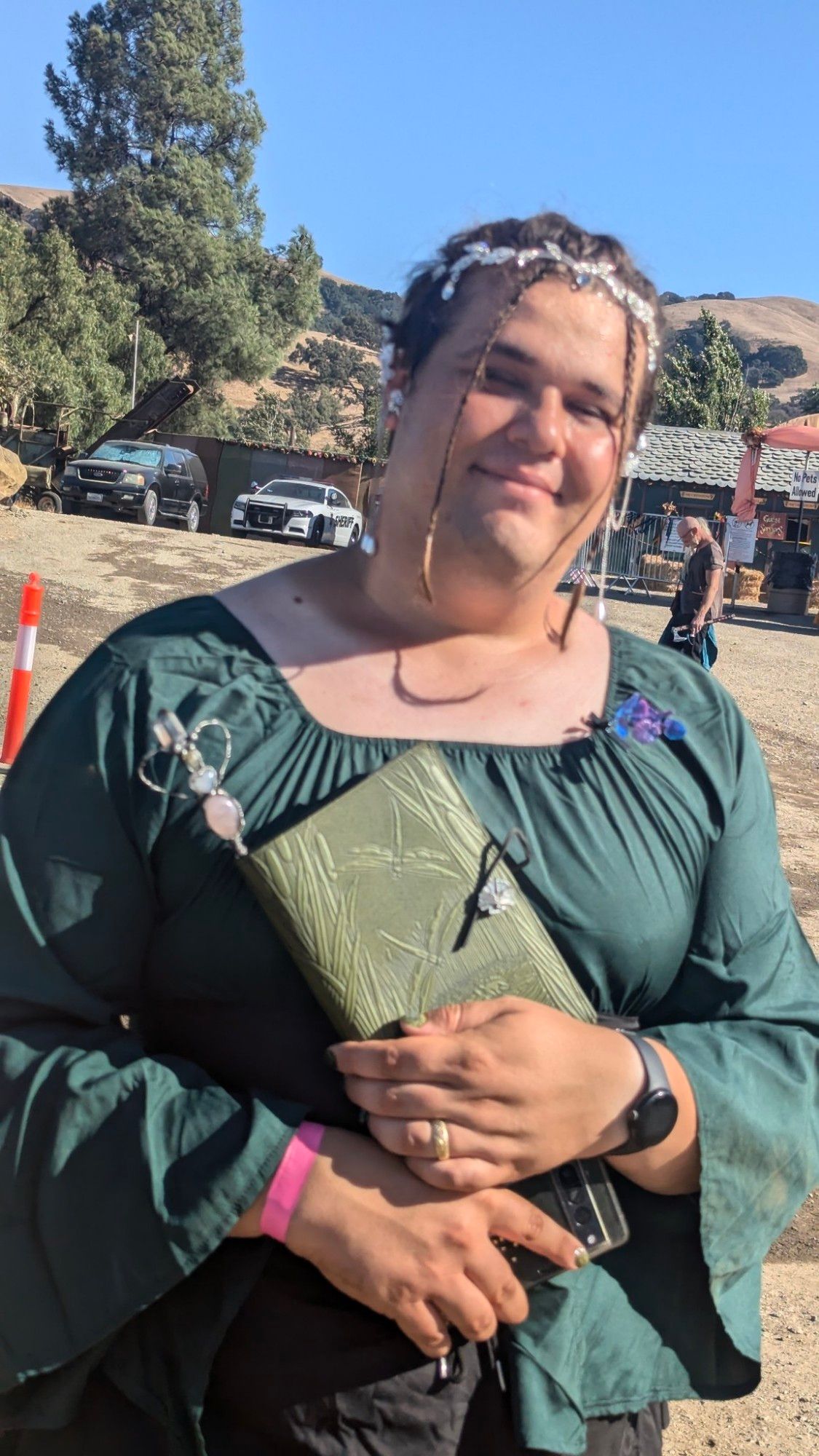 Picture of me in a Renaissance dress holding a journal I purchased. It's green with dragonfly patterns pressed onto it