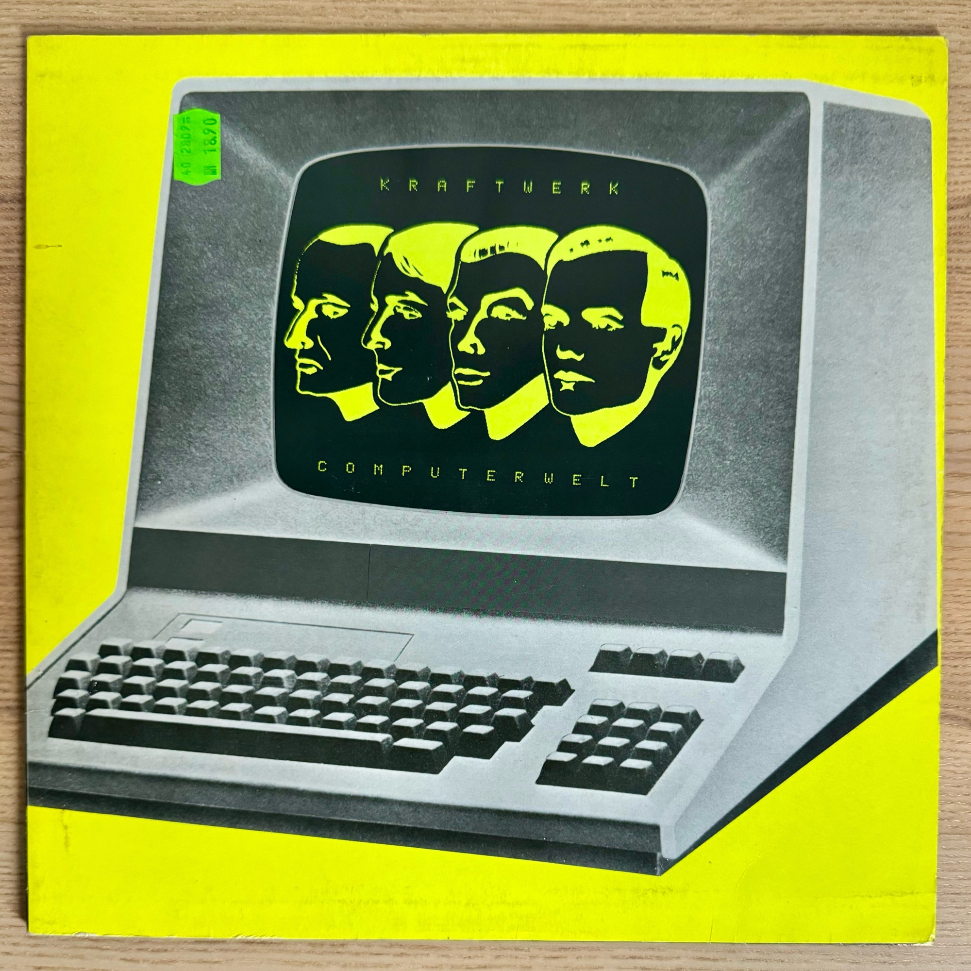 Bild der Kraftwerk-LP Computerwelt. Gelber Hintergrund mit einem Computerterminal auf dem die Gesichter der Bandmitglieder zu sehen sind.