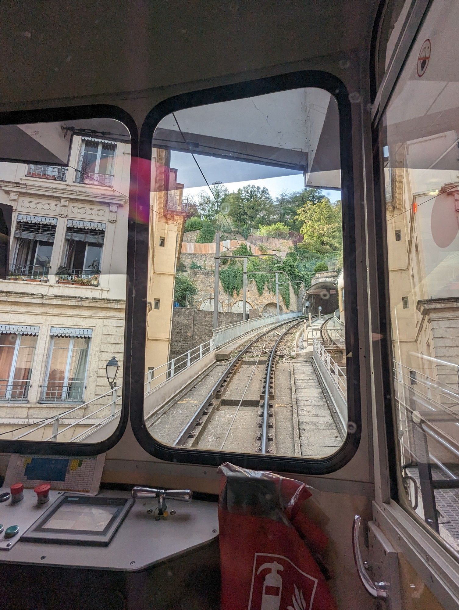 Blick aus der Standseilbahn Funiculaire de Lyon, die sich zwischen Häusern bergauf auf einen Tunnel zu bewegt.