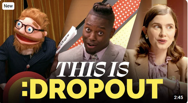 The cover image for This is Dropout shows a puppet version of Sam Reich, a cheery trickster with a beard and a suit. Next to him, Ify Nwadiwe, an immaculately dressed Nigerian man taps the side of his head. Next to him Vic Michaelis, a non-binary comedian dressed in a biege suit almost pulls off not corpsing at their latest guest.