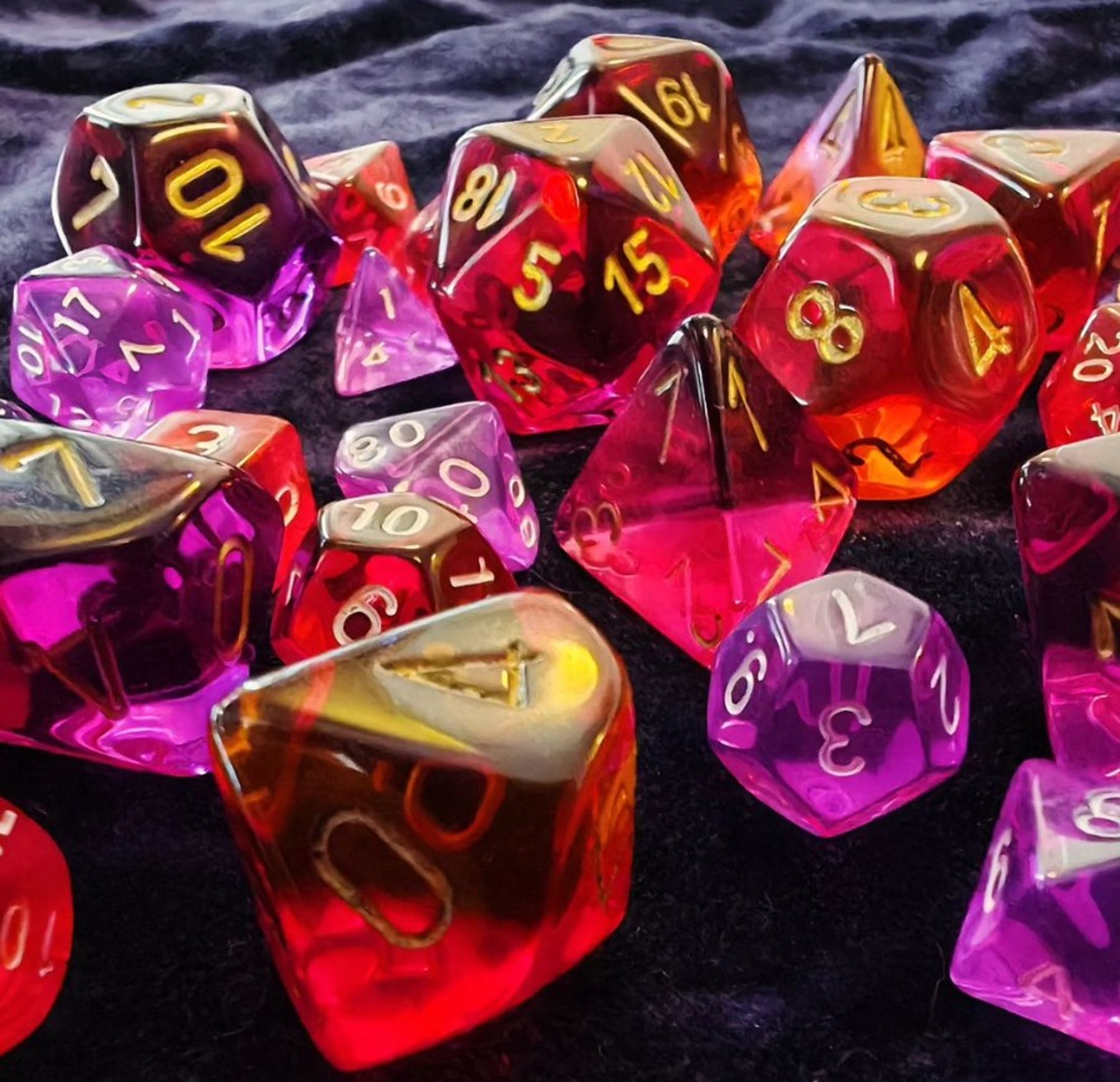 Translucent polyhedral dice in red and purple in two different sizes