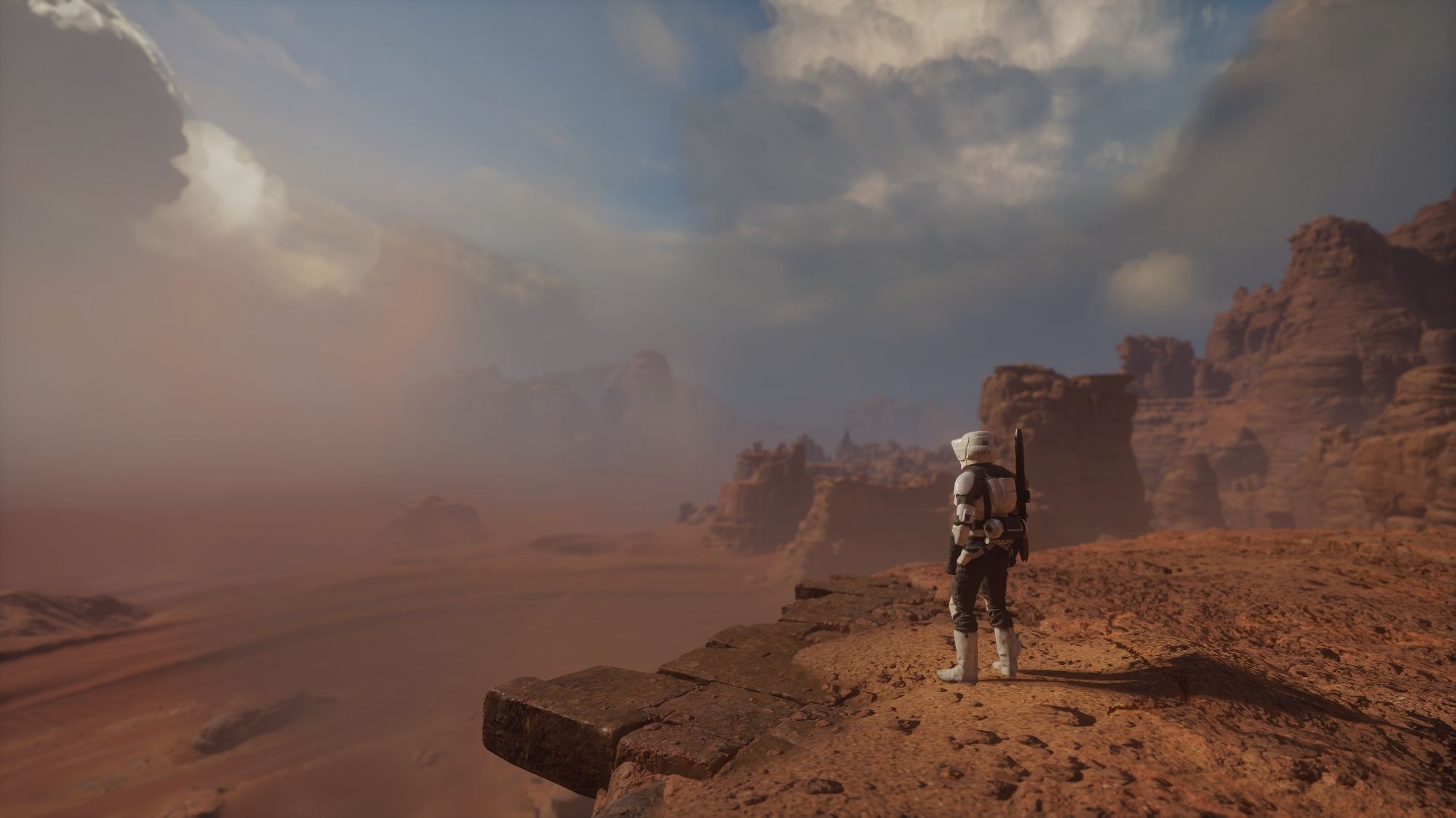 The image depicts a Stormtrooper standing on a cliff overlooking a vast, arid desert landscape. The Stormtrooper is wearing the standard white armor and appears to be gazing out at the distant horizon. The sky is filled with dramatic clouds, and the sun is setting, casting long shadows across the desert. The scene evokes a sense of solitude and contemplation, as the Stormtrooper stands alone in the vast, empty landscape.