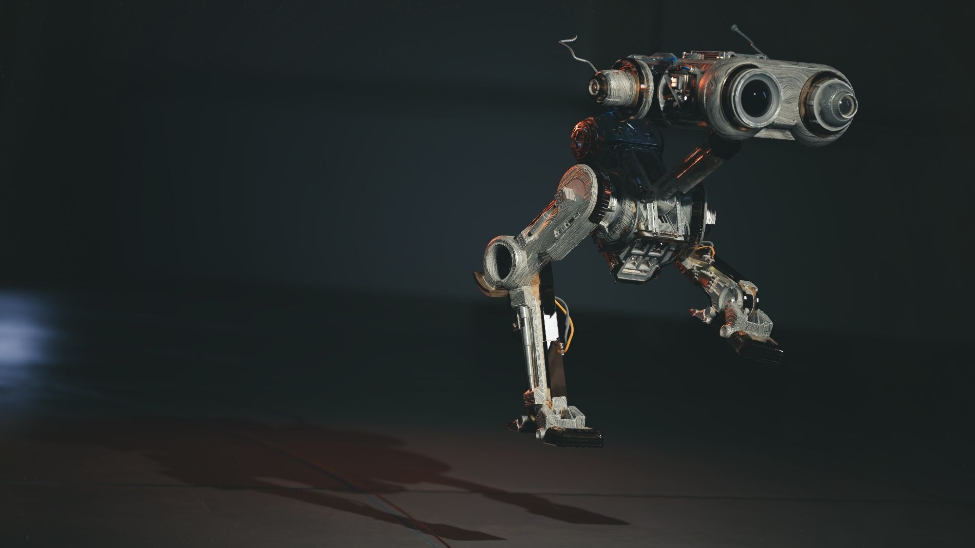 A close-up of BD-1 from Jedi Survivor. It's hovering in mid-air, its legs extended as if in a playful jump. The droid's body is covered in a weathered, metallic exterior, and its twin periscopes are angled forward. The background is dark and shadowy, emphasizing the droid's form and the dynamic nature of its movement.