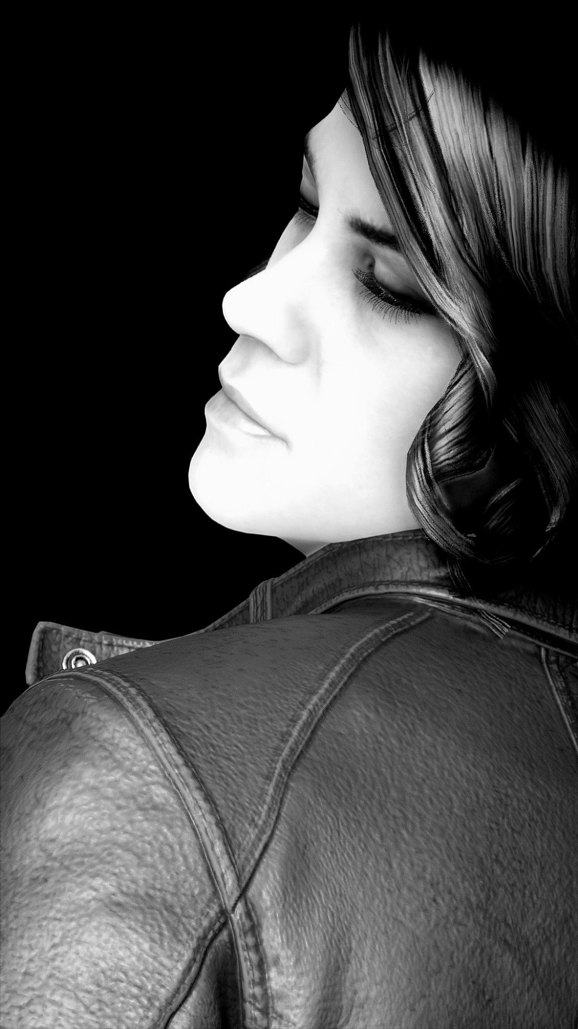 A vertical, stark black & white portrait of Jesse Faden from the shoulders up and from her left shoulder to the middle of her back. Her body is turned away from the viewer with her head turned over her left shoulder. Her face and the hair falling down the left side of it are brightly lit while the background is completely black. Her expression is serene. She is wearing a black leather jacket. 