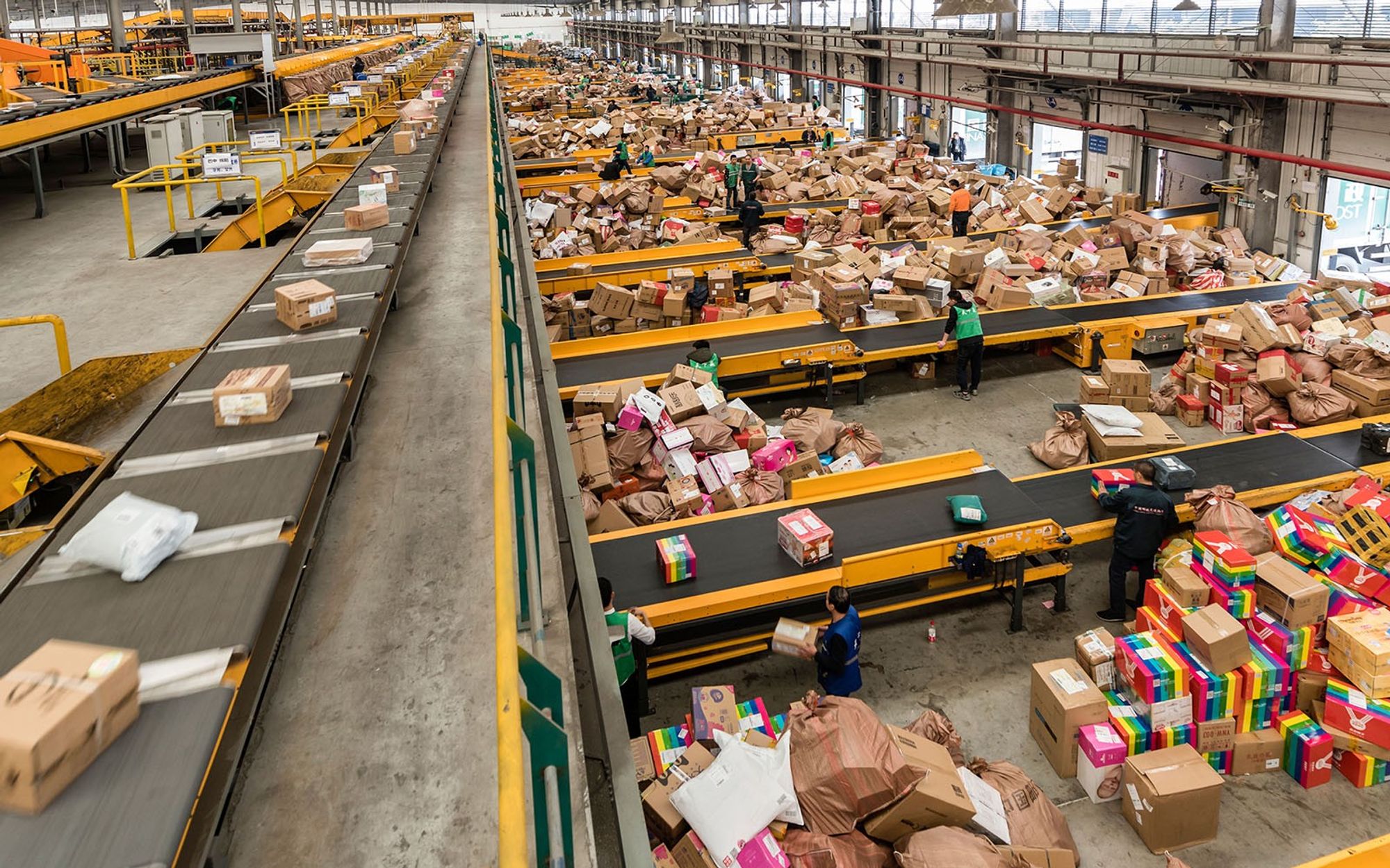 Warehouse overwhelmed with packages and small group of workers