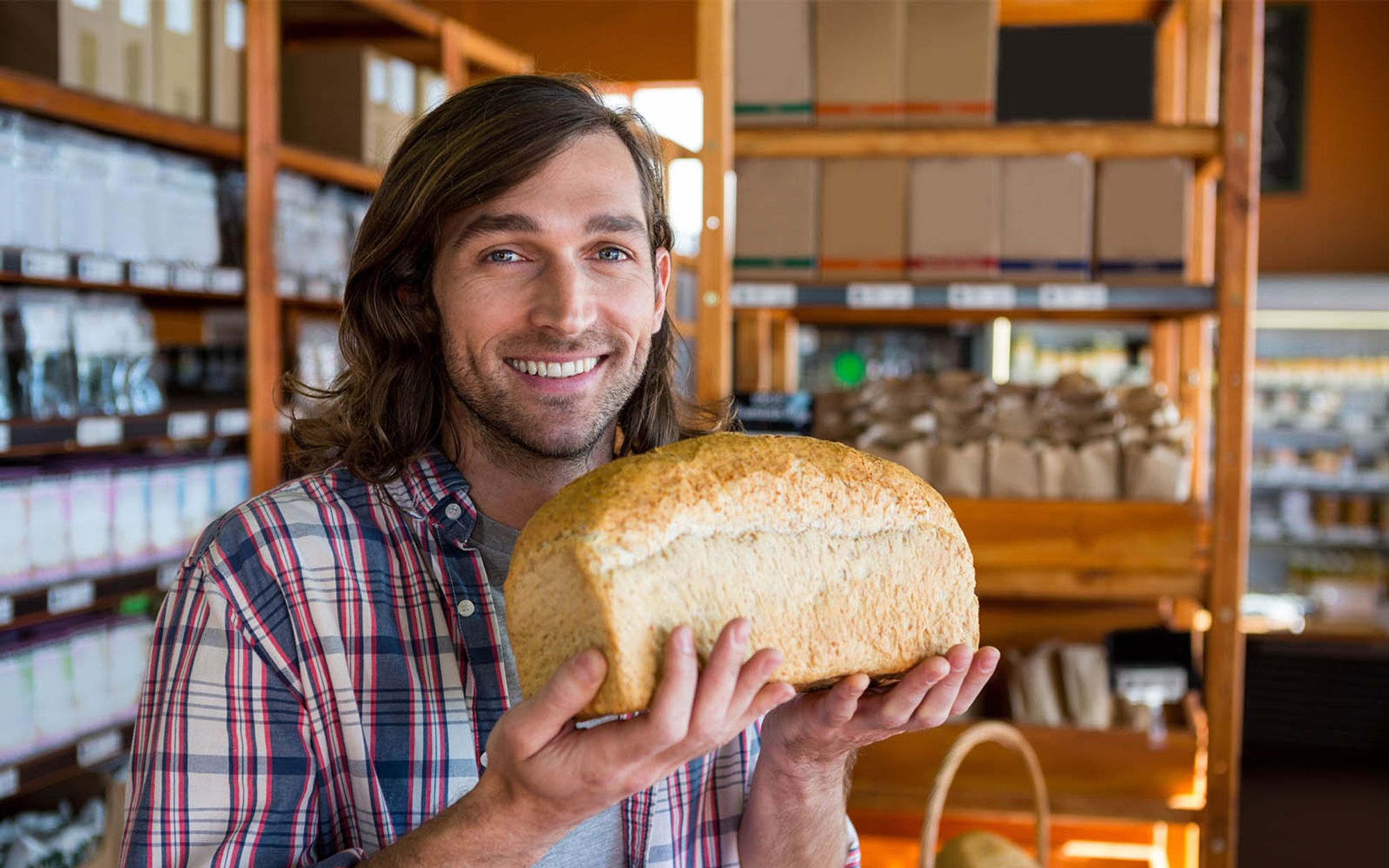 Man at store holding bread smiling