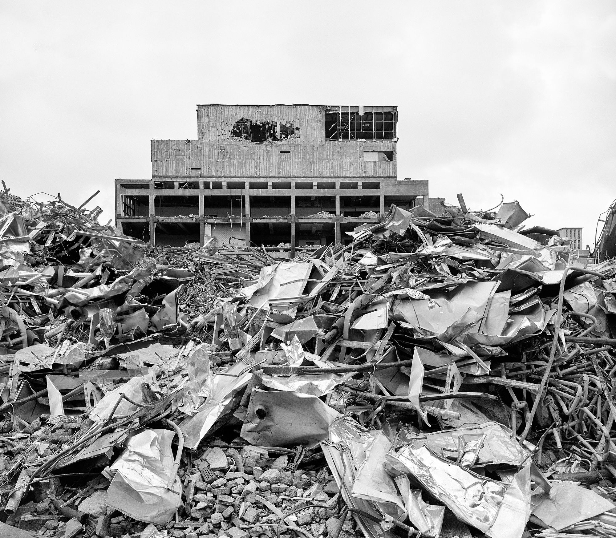 Schuttberg voller Metallschrott im Vordergrund, dahinter Ruine. Abriss an der Mainzer Landstraße/Hellerhofstraße, FAZ Gelände, Frankfurt Gallus. Fotografie schwarzweiß analoges Großformat 4x5 auf Kodak Plus-X Pan, Format 4x5, Expired 11/1984 ---- 355-P9-abbruch-22-05-2024-co-1-1