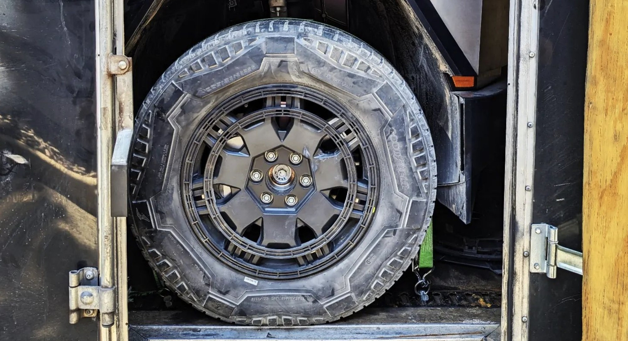 a stock cybertruck tire with the rim cover removed, showing the custom molded cutaway detail.