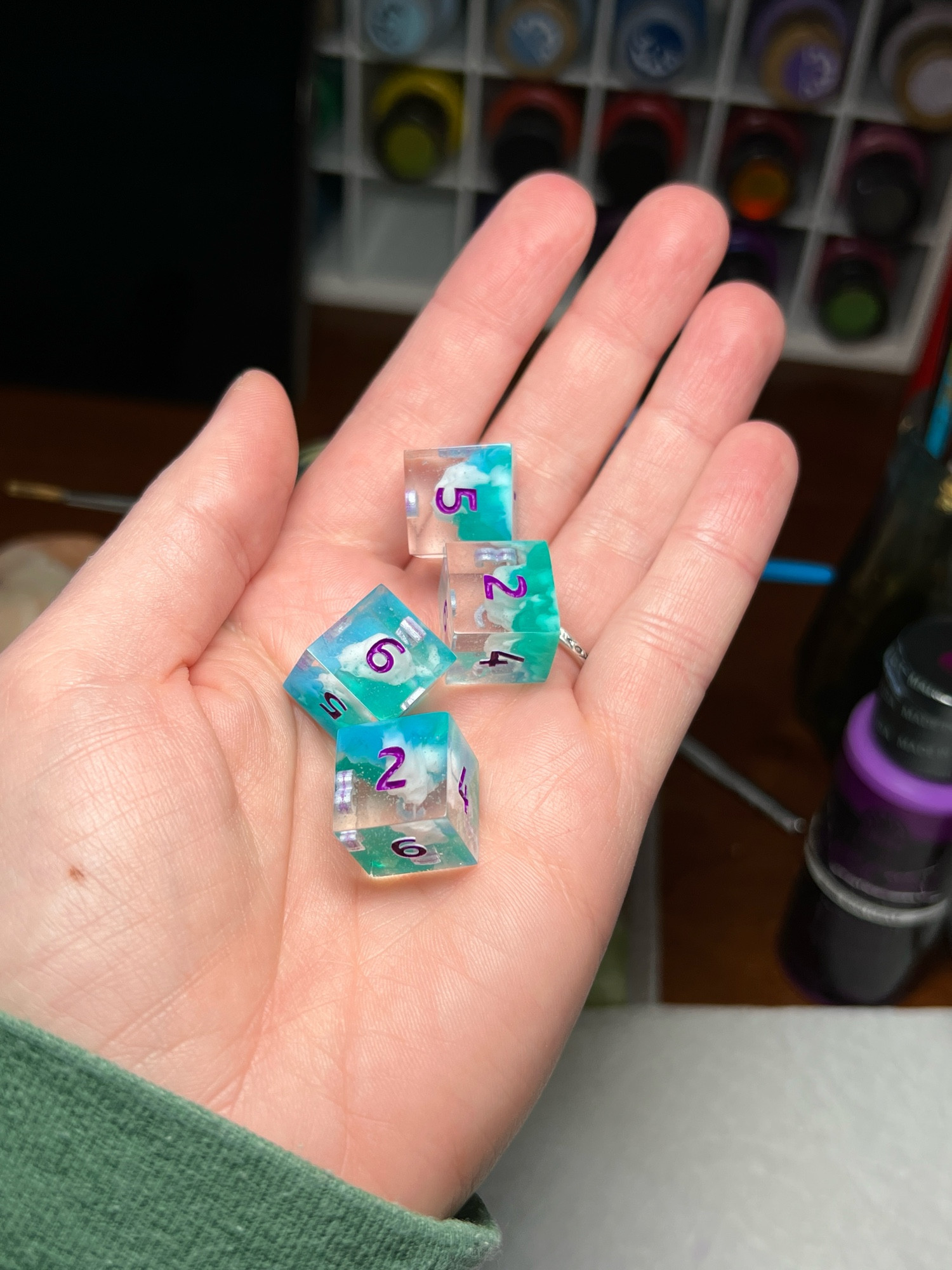 A custom 4 d6 set I made in clear, blue, aqua green and white with neon purple numbers. 