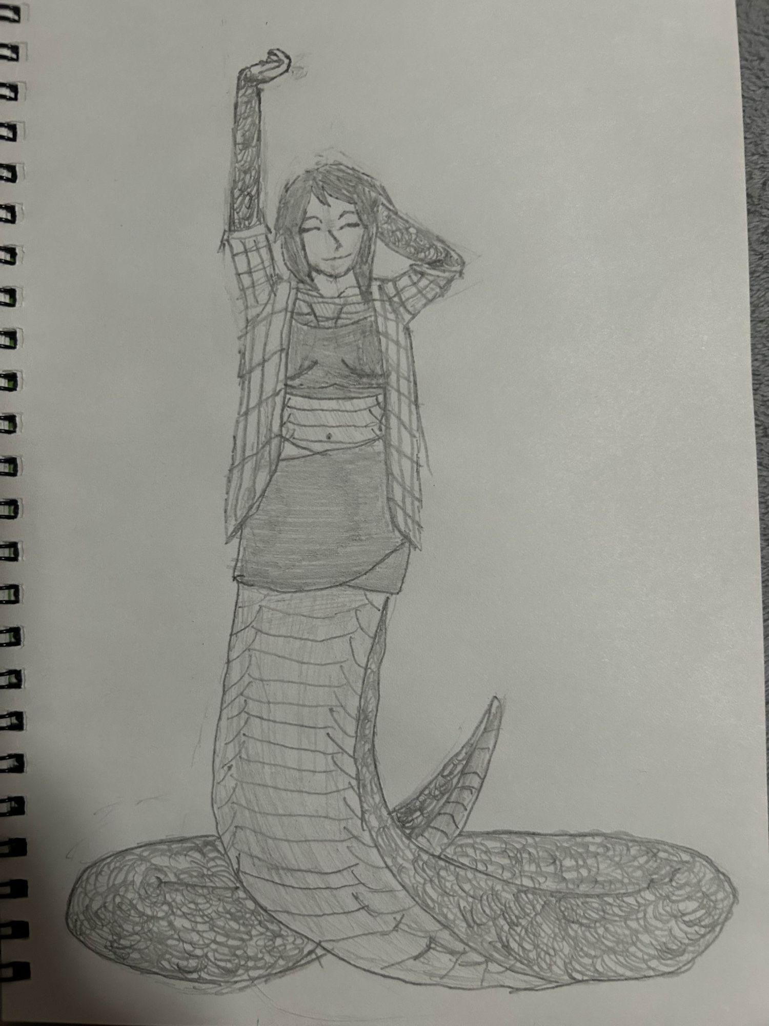 A woman with the tail of a snake and covered in scales, her arms are stretched out to the sky, she is wearing an open plaid shirt with a sports bra underneath and a dark cloth wrapped around her waist.