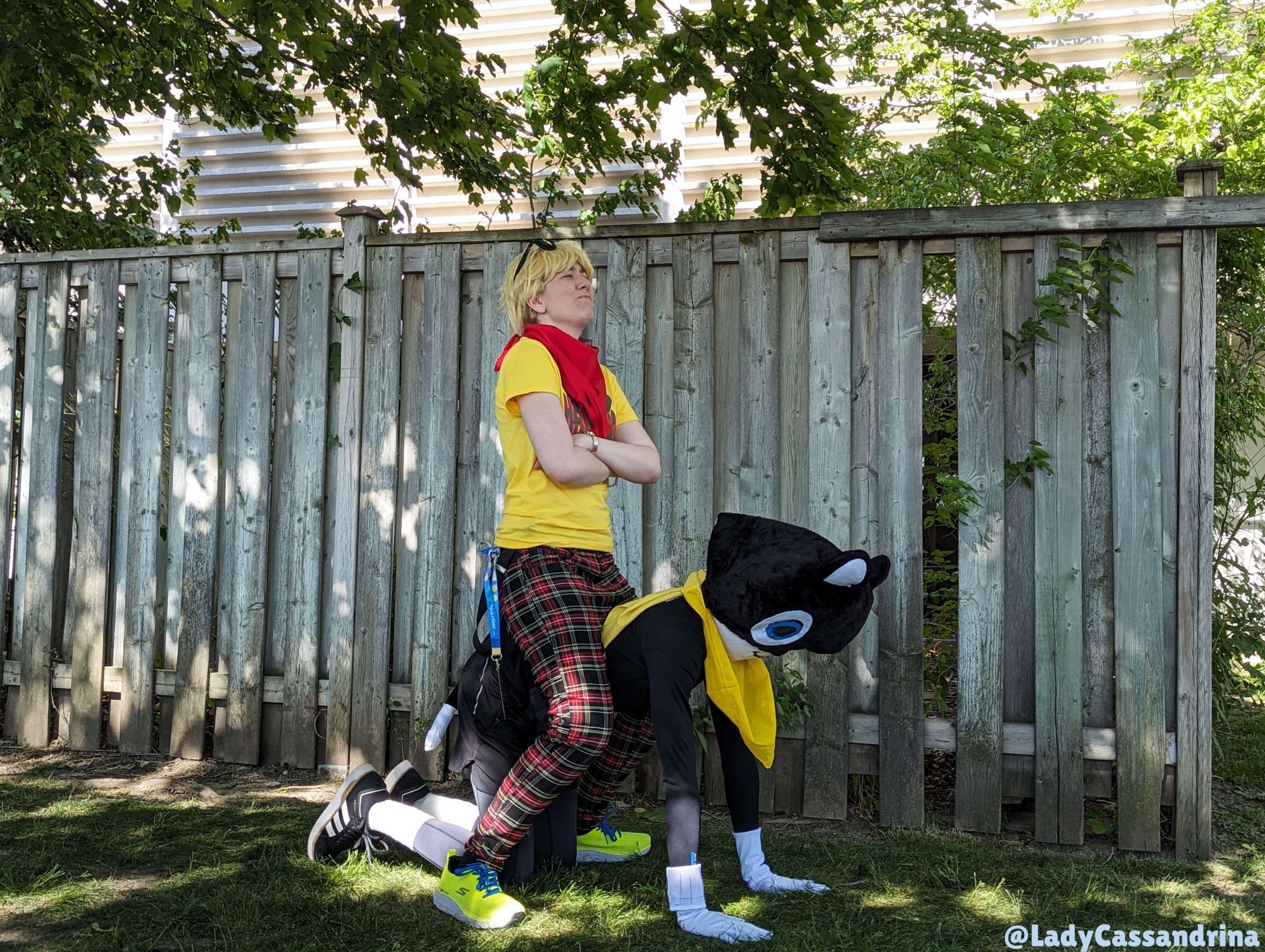 Anime North Persona Photoshoot. I'm seated atop a full suited Morgana cosplayer (as Ryuji) with a smug look on my face and my arms crossed. AGAIN! Major props to this dude! This shot was so funny!