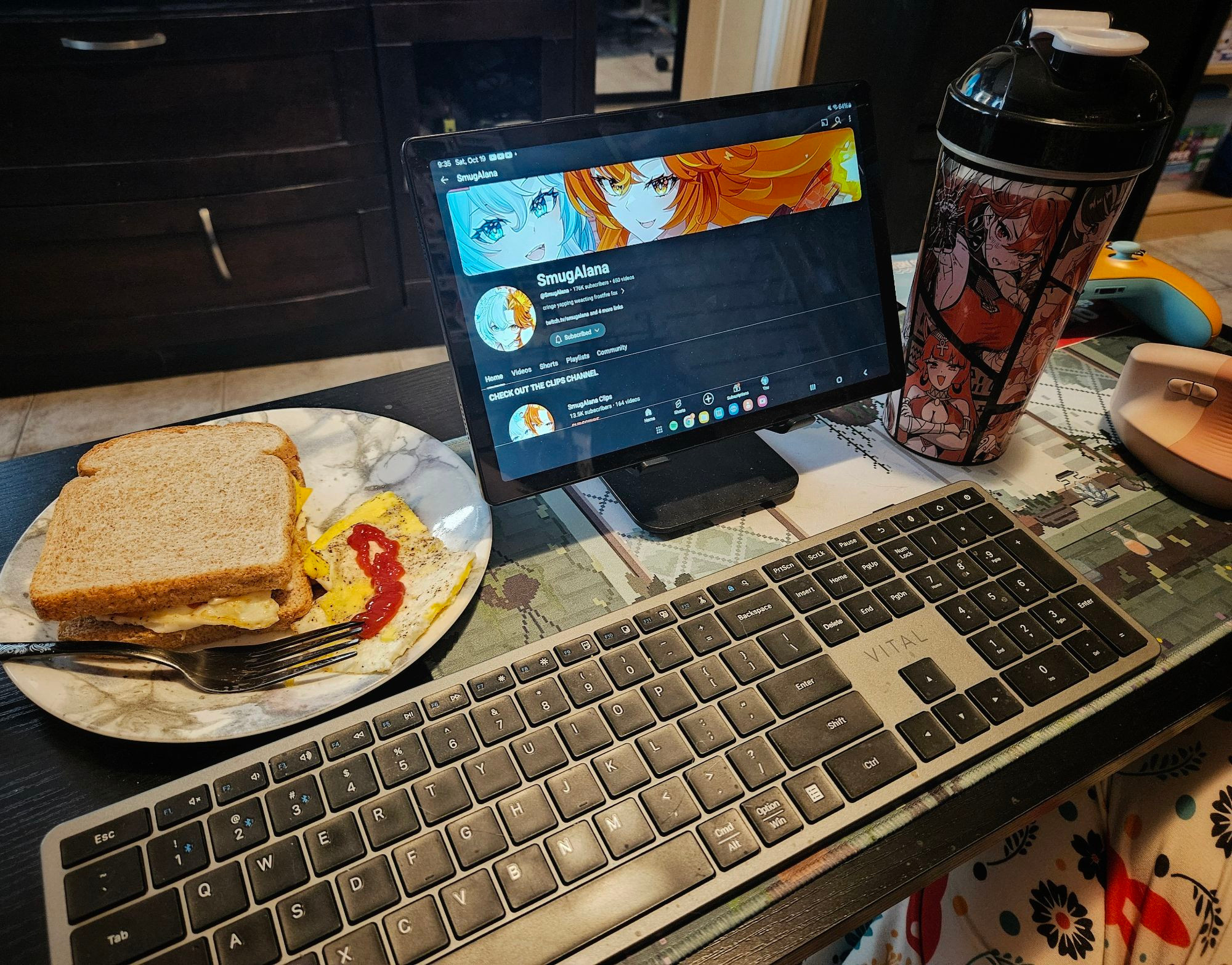 Picture of egg sandwich with SmugAlana on a tablet screen and a waifu cup filled with goof juice