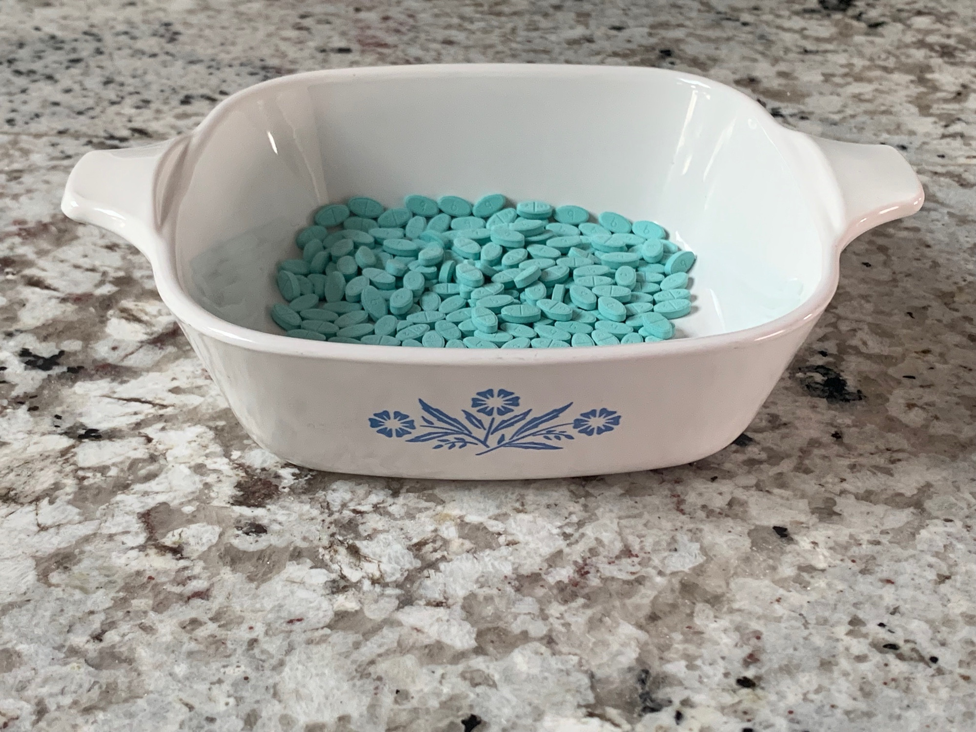 a small white dish holding a pile of estradiol tablets