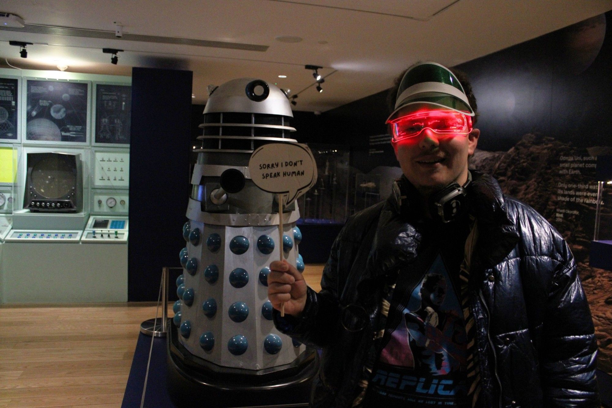 Man with Dalek, holding a sign.