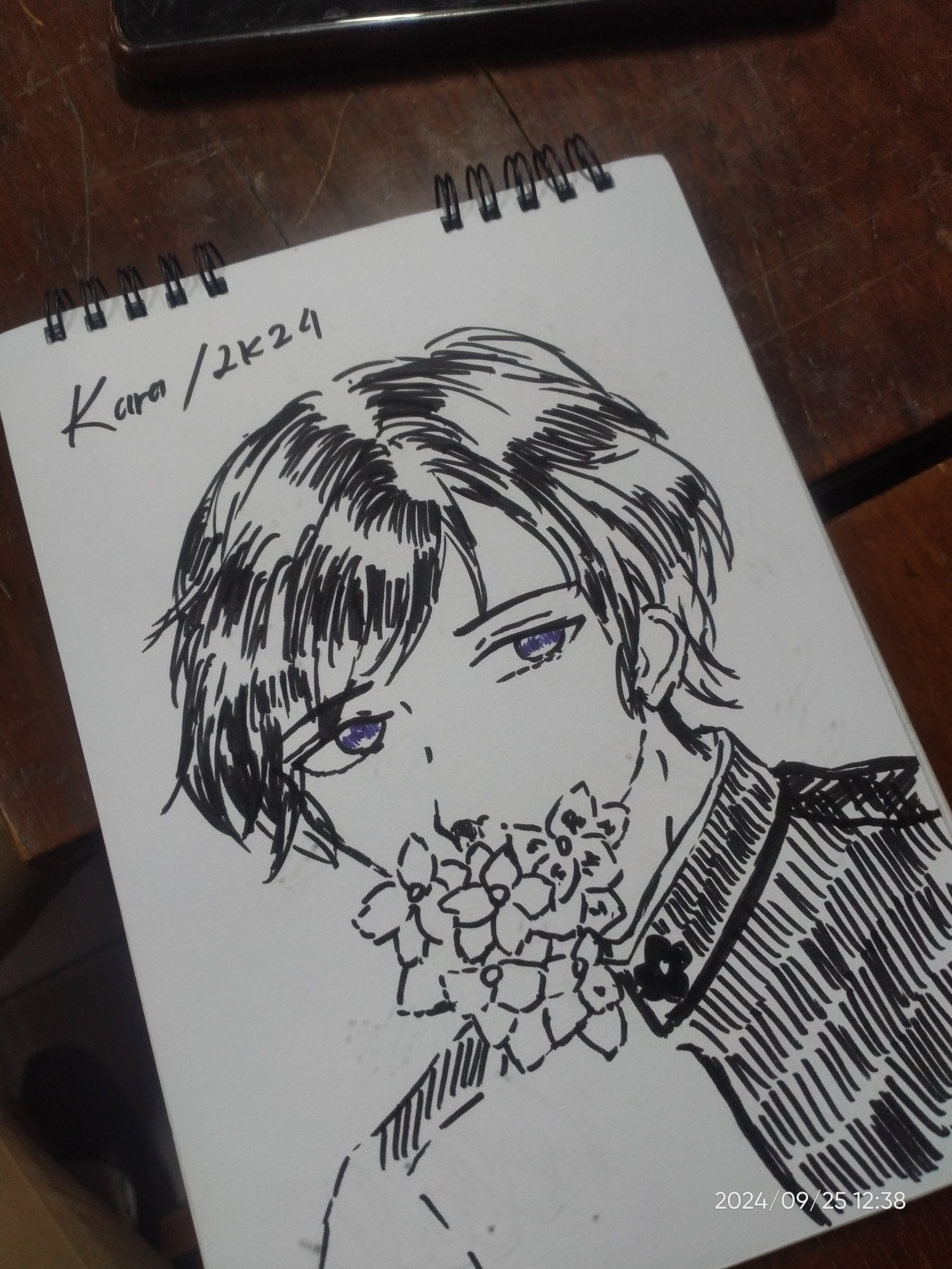 An art of a black-haired male character with a pair blue eyes, which is drawn on a paper using black inked artline marker.