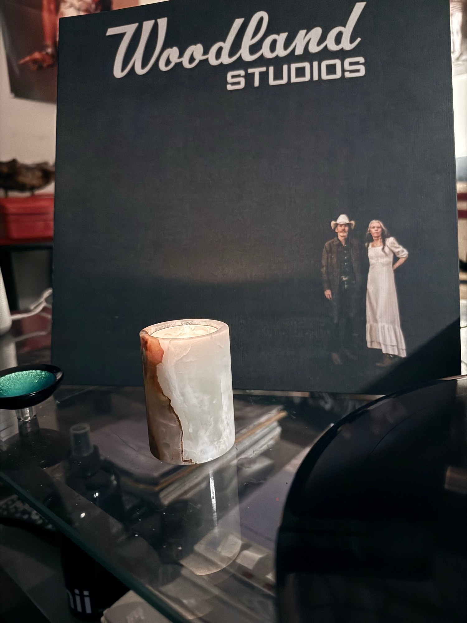 A photo of the cover of ‘Woodland Studios,’ by Gillian Welch and David Rawlings, by candlelight. 