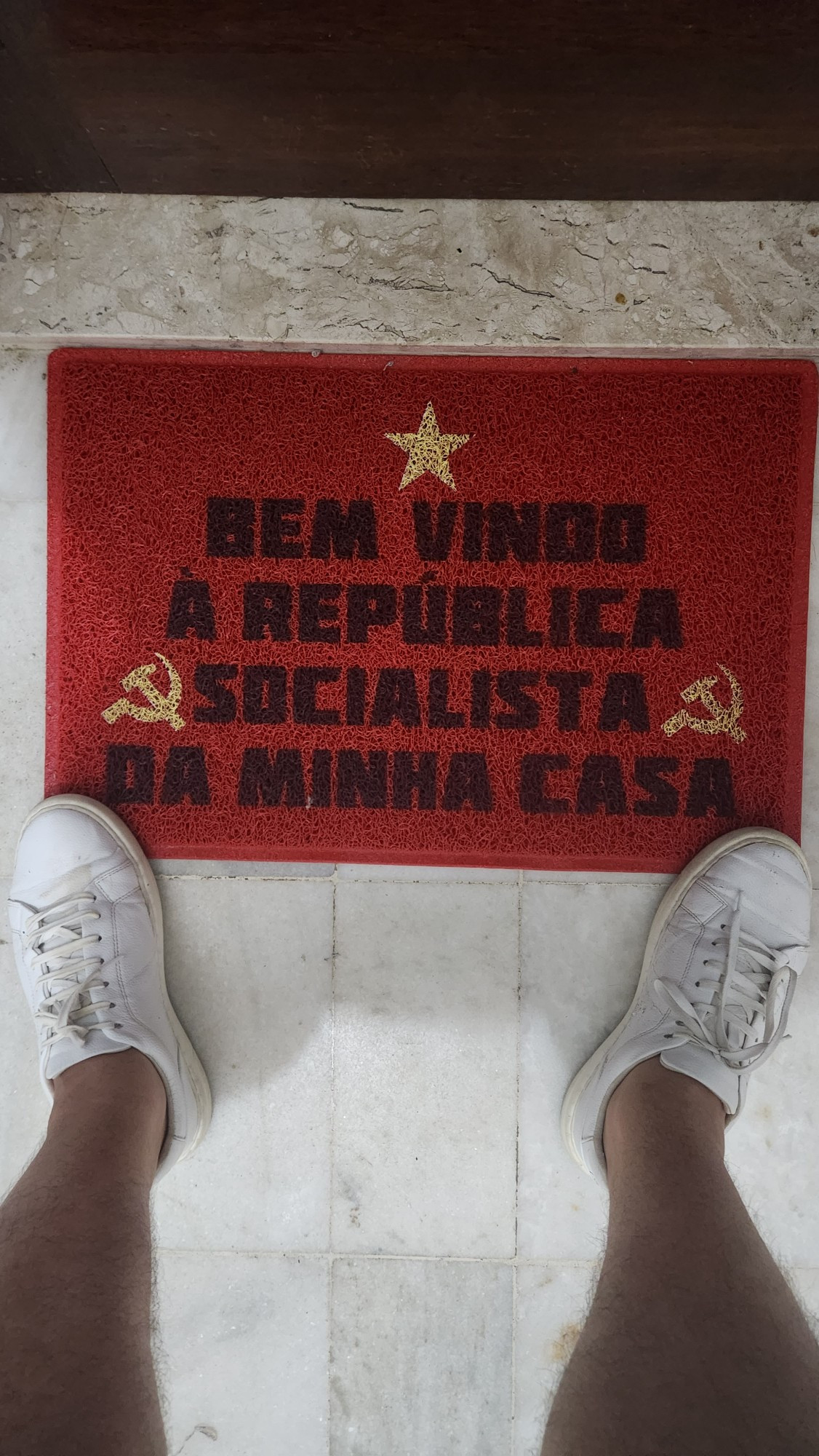 Carpete escrito Bem Vindo a República Socialista da minha casa. O carpete faz referências a bandeira da Rússia comunista