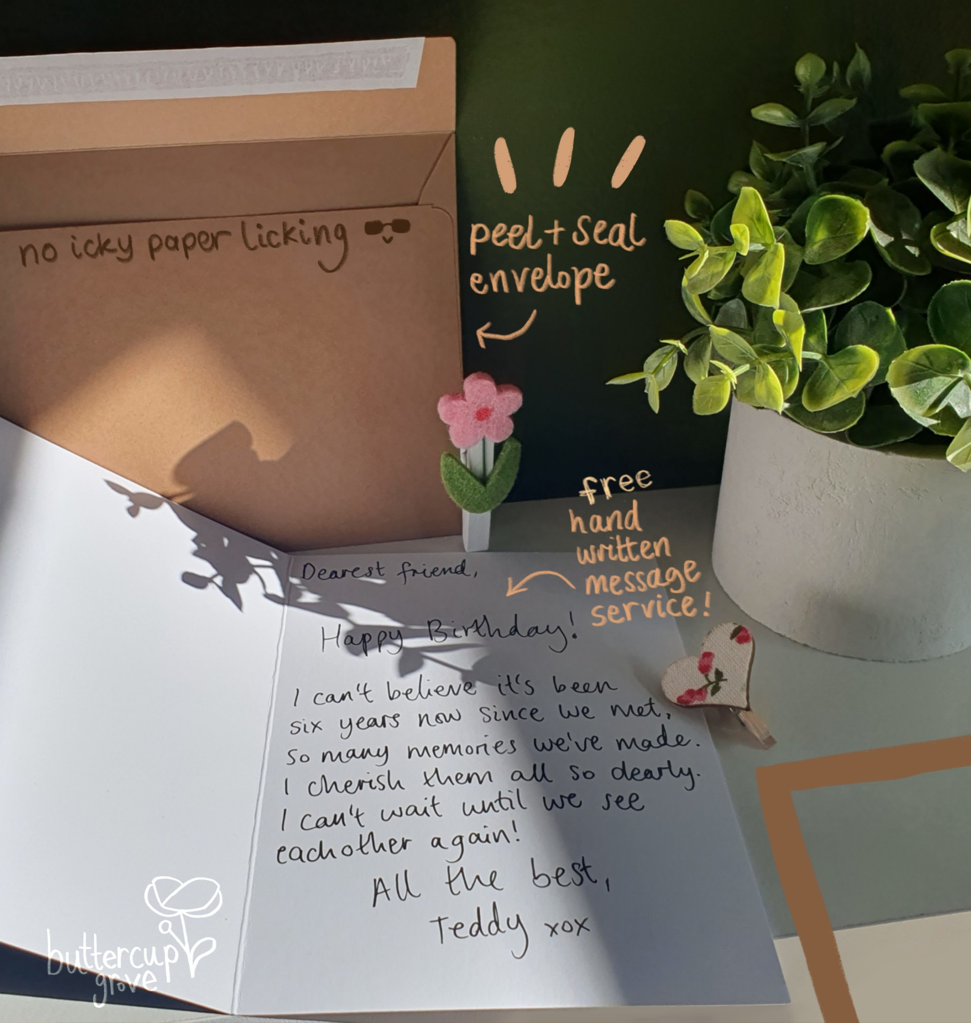 photo of an open greetings card and a brown envelope sat in sunshine, with digitally handwritten writing in yellow drawn on top. the writing points to the envelope and says 'peel and seal envelope' and 'no icky paper licking', and another arrow points to the writing in the card and says free hand written message service.