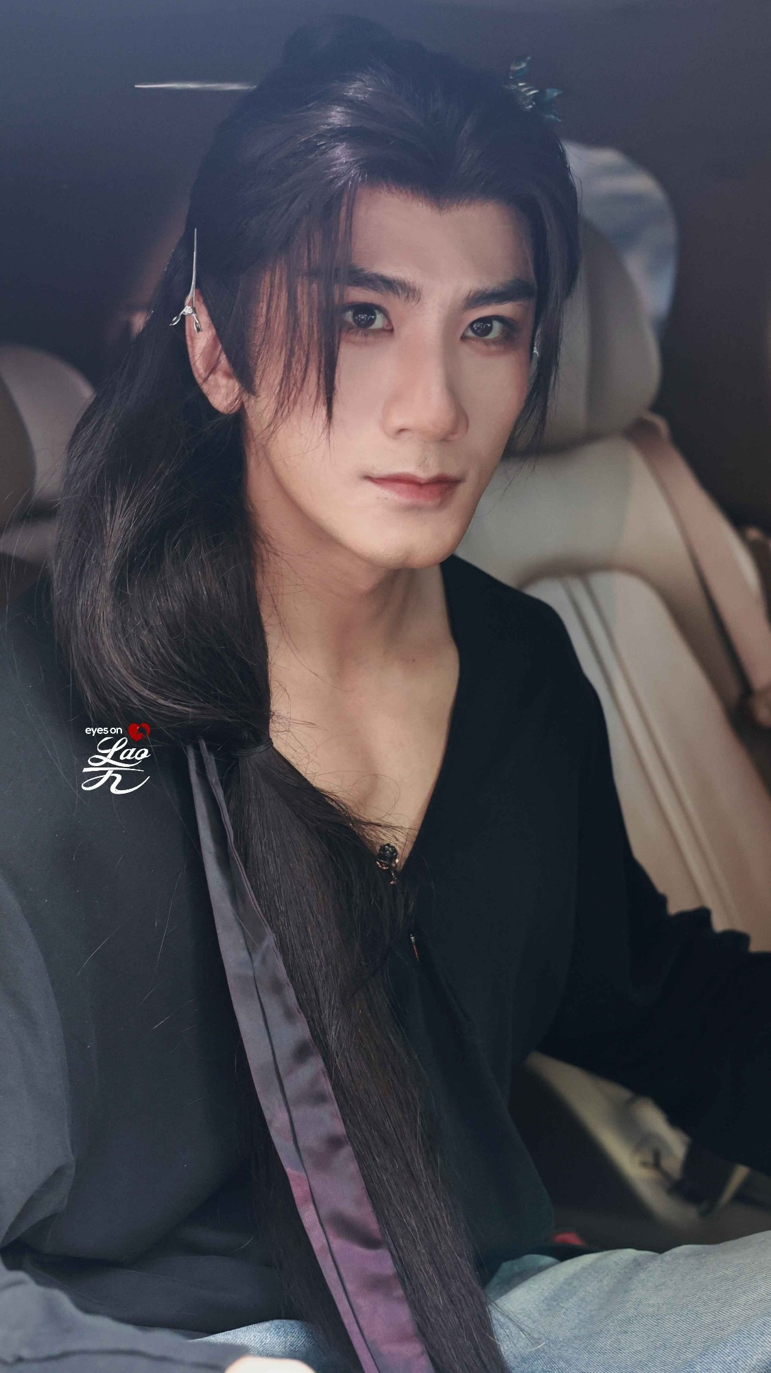 Xiao Shunyao sitting in the car with his long black wig and deep neckline looking very pretty