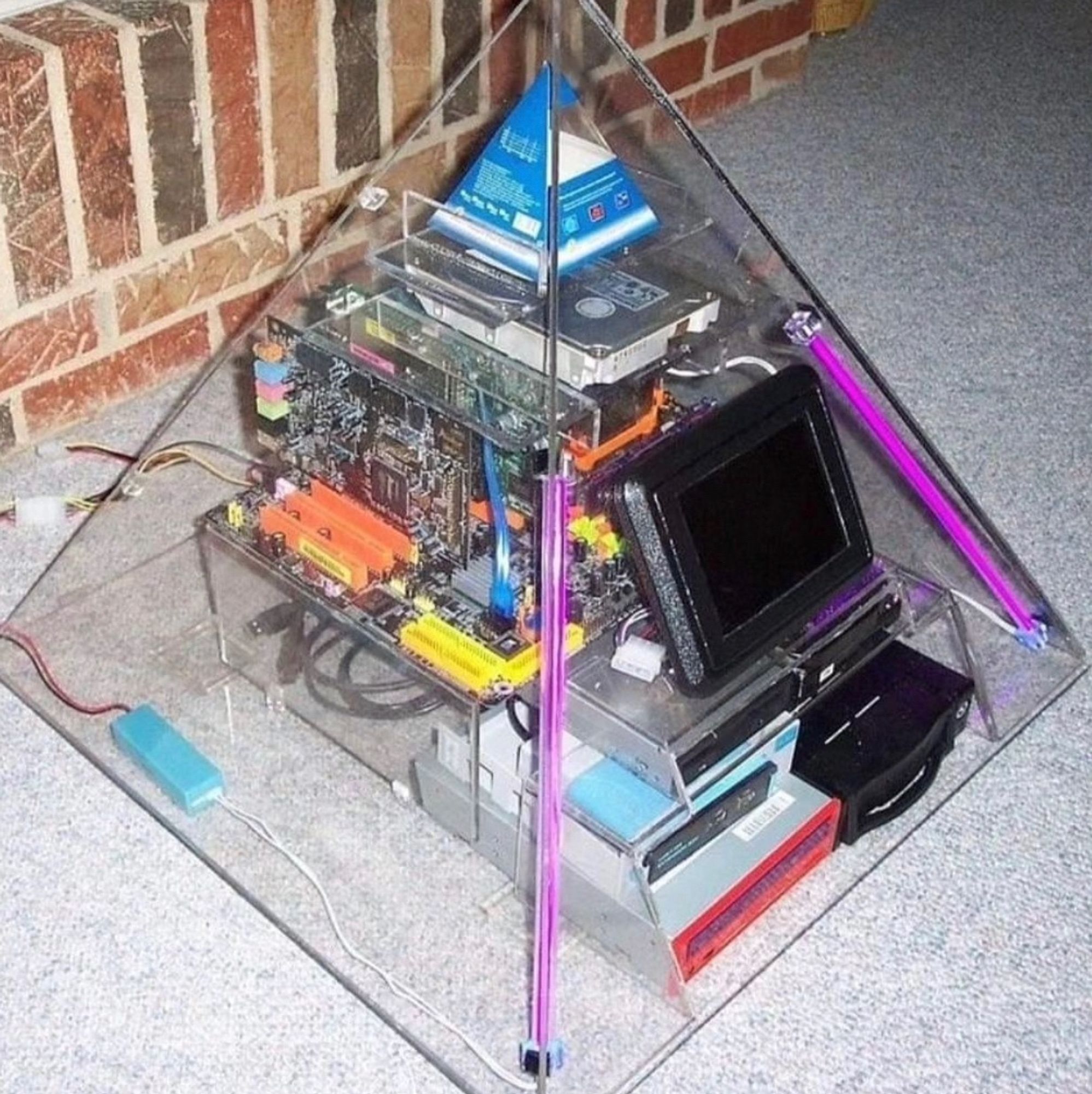 some sort of computer housed inside of a transparent pyramid so you can see the inner workings