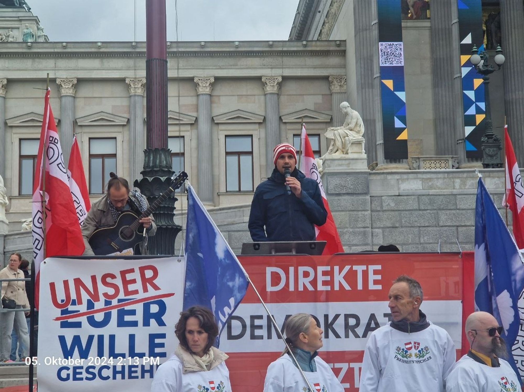 Ein Foto vom Parlament in Wien, davor ein paar Vollidioten.