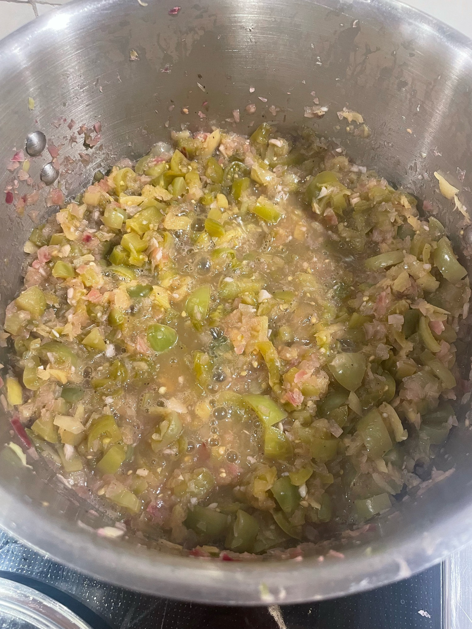 A bit pot of simmering greenish yellow salsa.