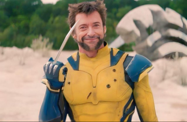 Hugh Jackman en Wolverine est tout sourire face à la caméra et nous montre son poing droit, laissant voir la griffe centrale sortie, comme s'il nous tendait son majeur