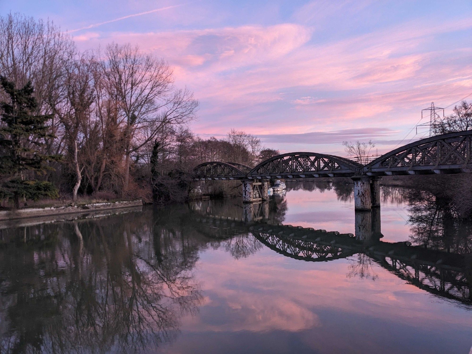 Bridge over a river at sunset. Sky and water reflection in blue and purple shades