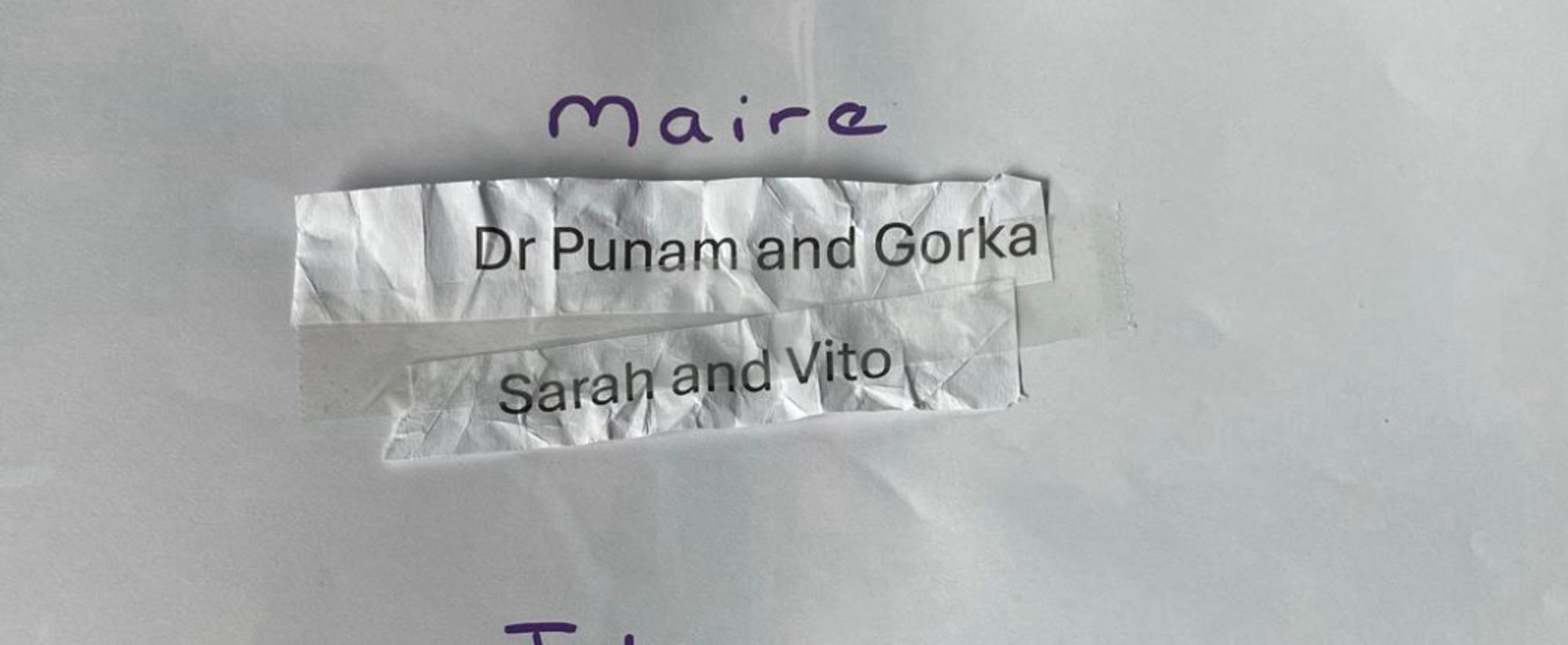 Paper with Máire written on it and two smaller bits of paper stuck underneath. They say “Dr Punam and Gorka” and “Sarah and Vito”