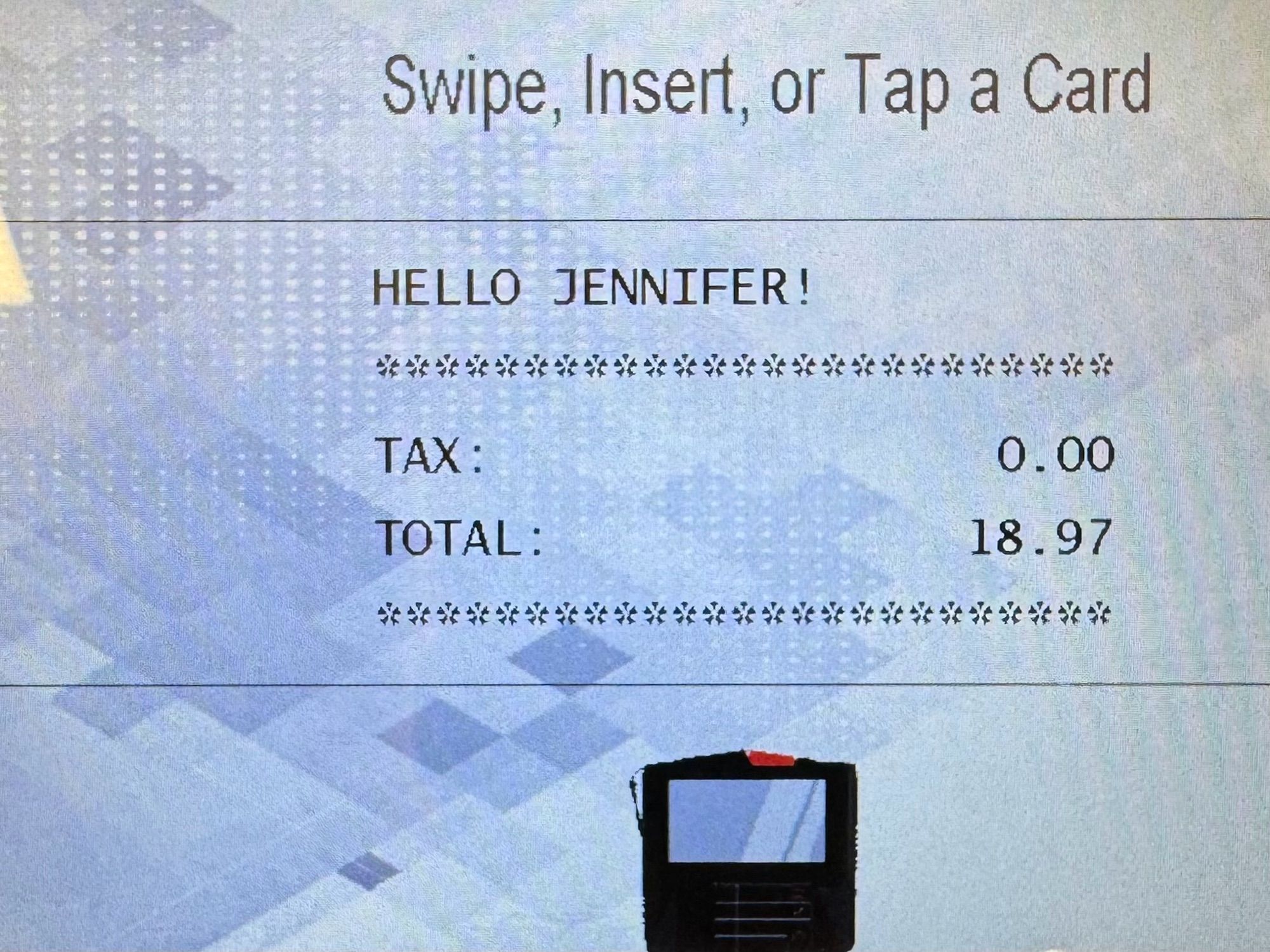 A credit card terminal with a total, and a prompt that says “HELLO JENNIFER!”