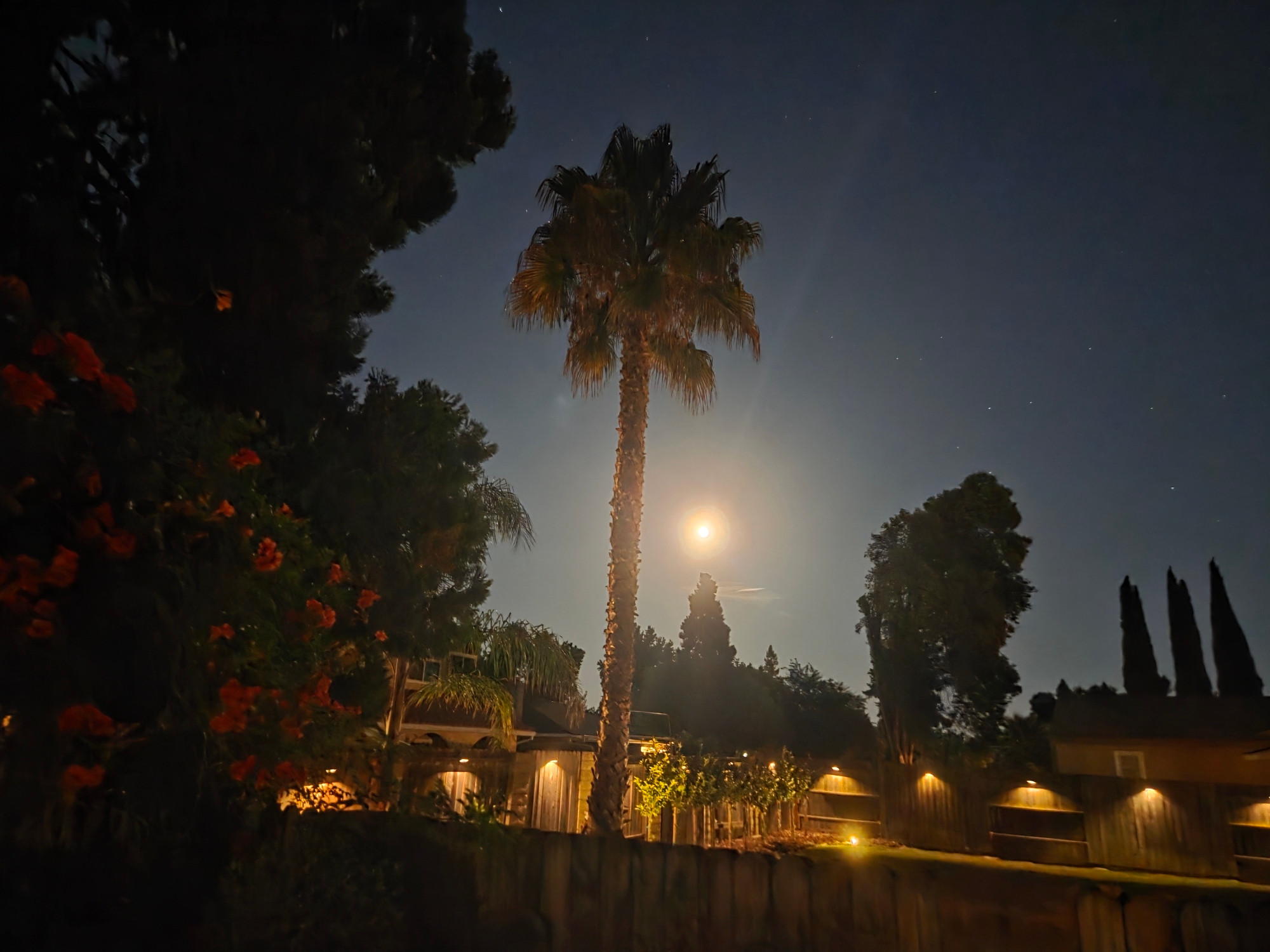 A photo of the full moon with faint beams radiating from it. 